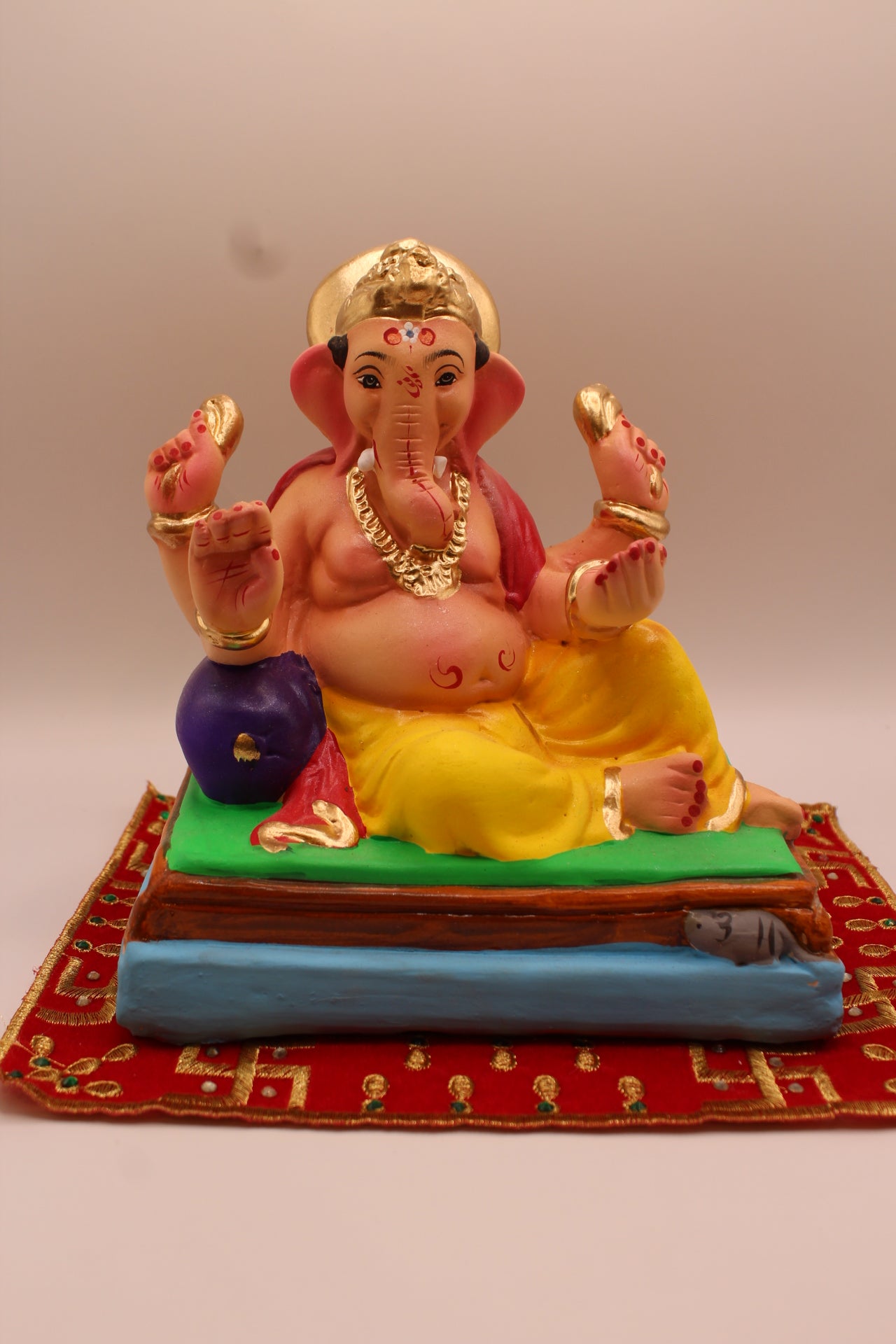 Eco-friendly 8 inch Ganesh Visarjan idol in rose shawl and yellow dhoti, relaxed pose – front view