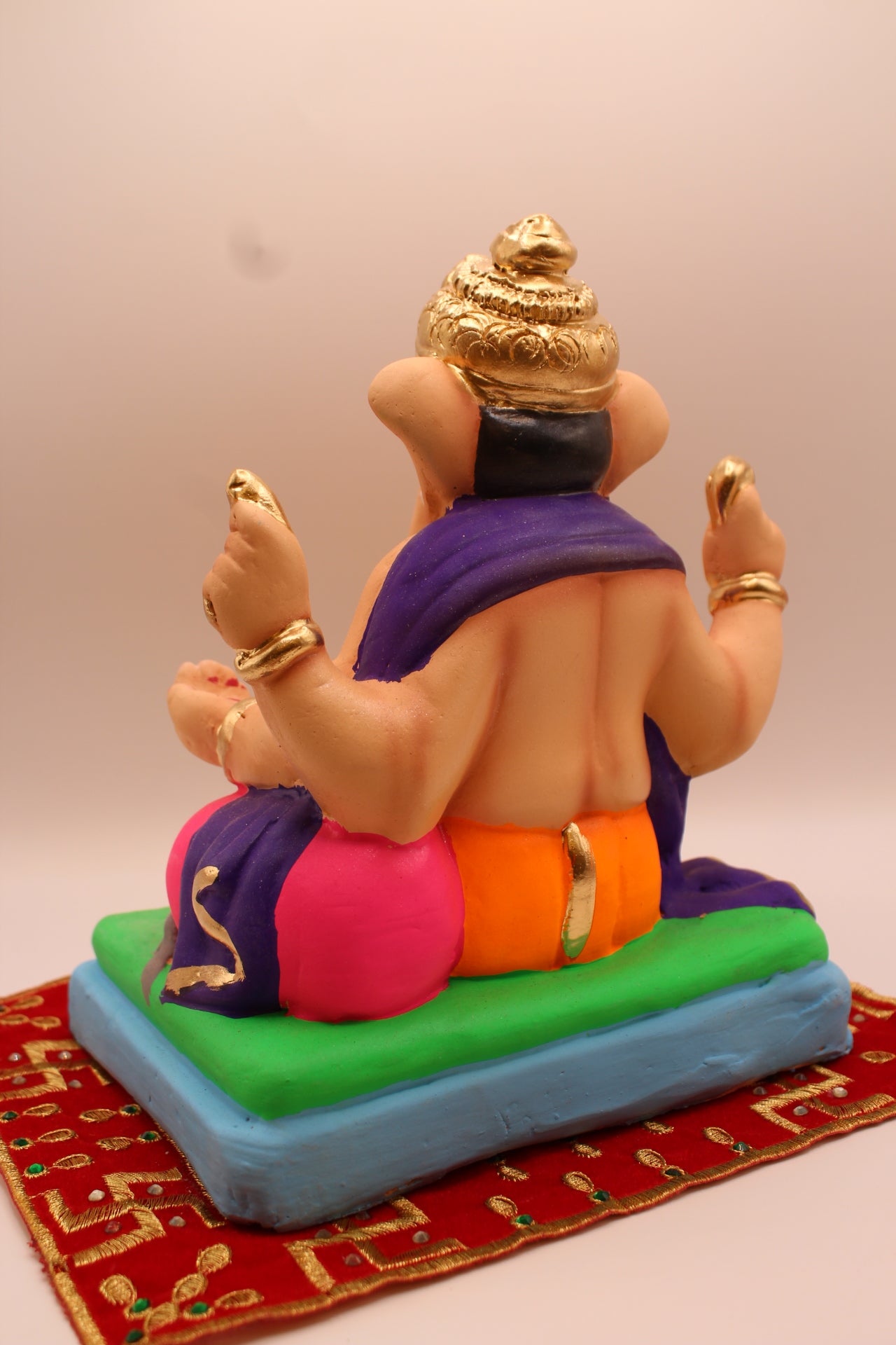 Eco-friendly 8 inch Ganesh Visarjan idol in purple shawl and orange dhoti – back view