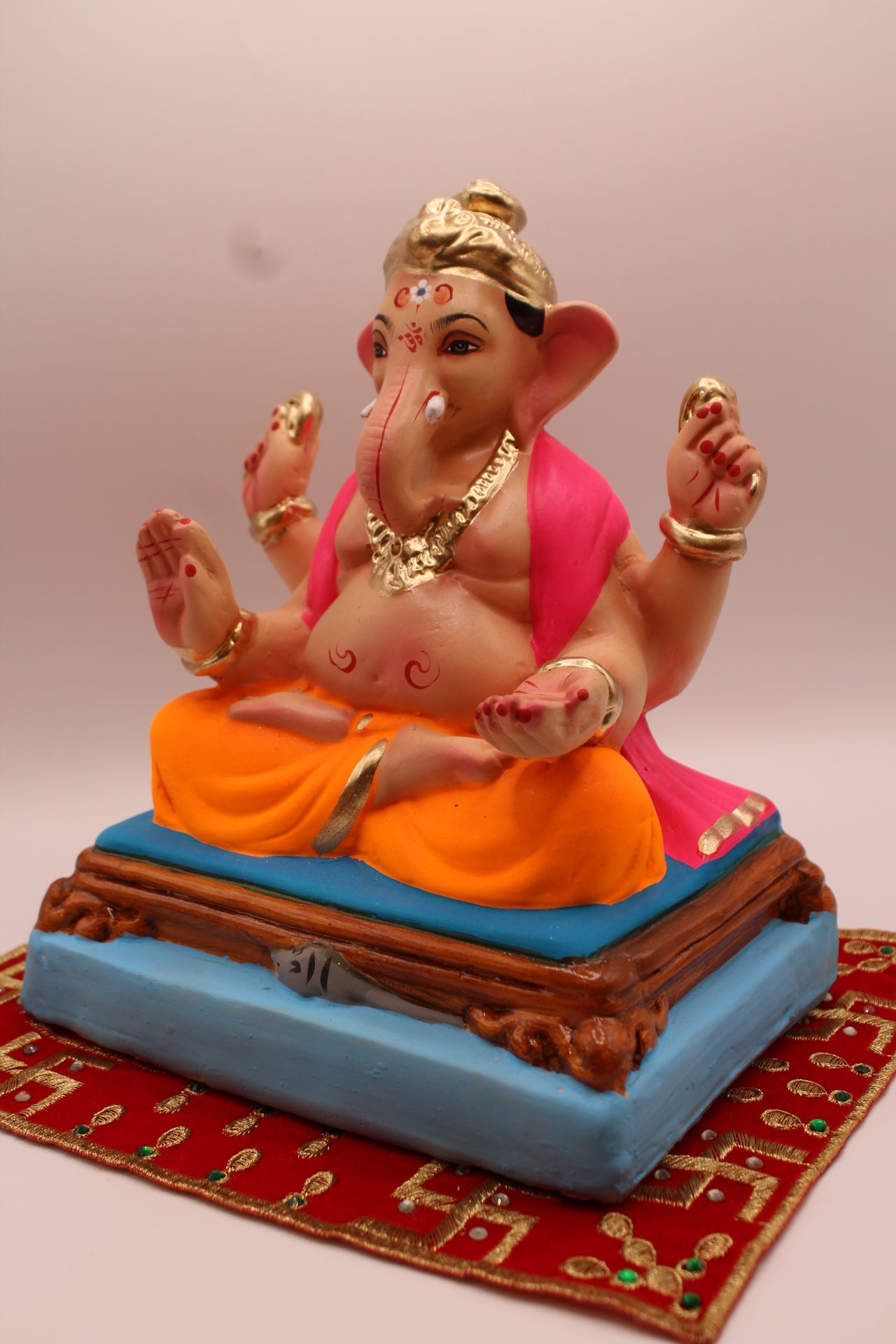 Eco-friendly 8 inch Ganesh Visarjan idol in pink shawl and orange dhoti – detail view