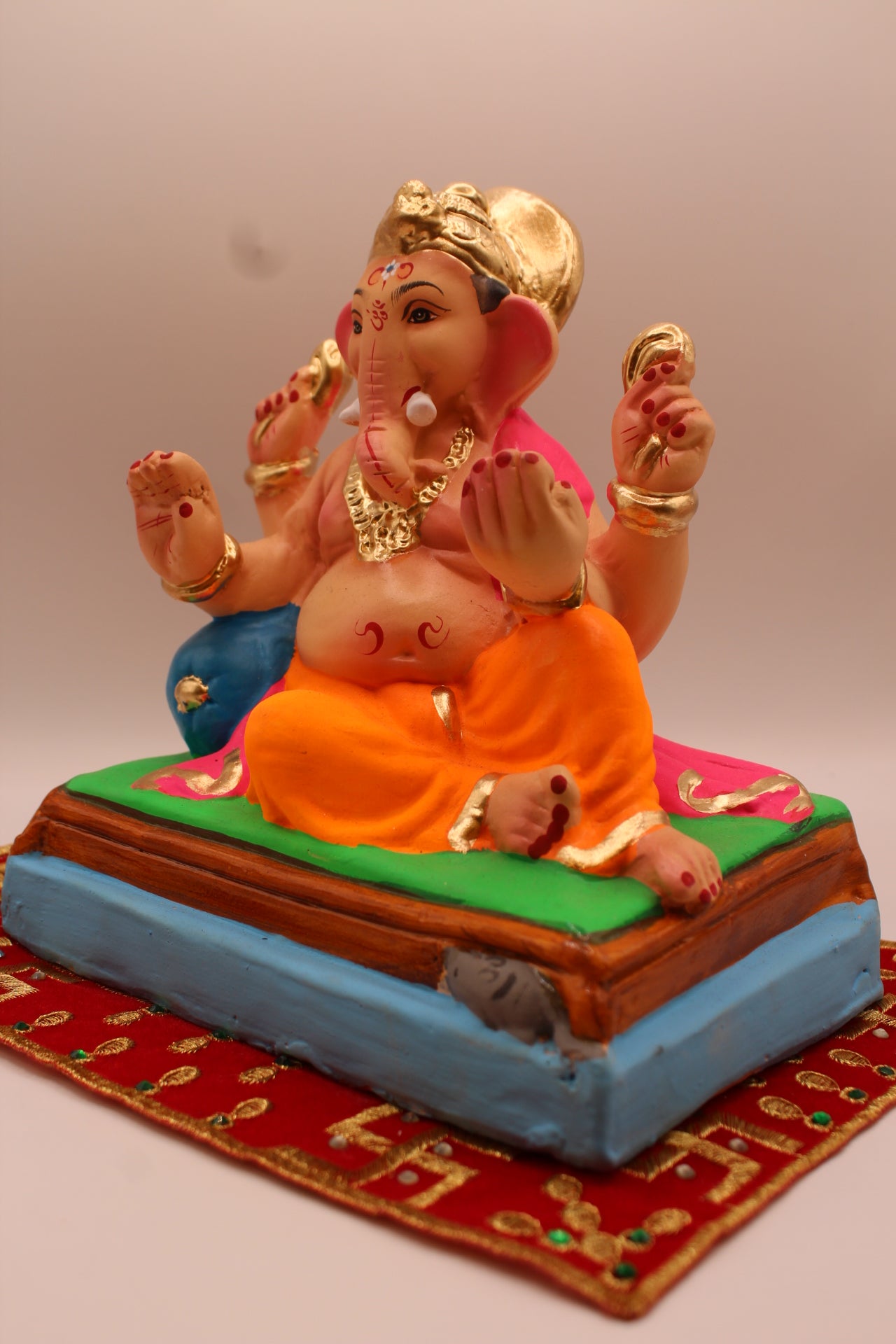 Eco-friendly 8 inch Ganesh Visarjan idol in pink khes and orange dhoti – detail view
