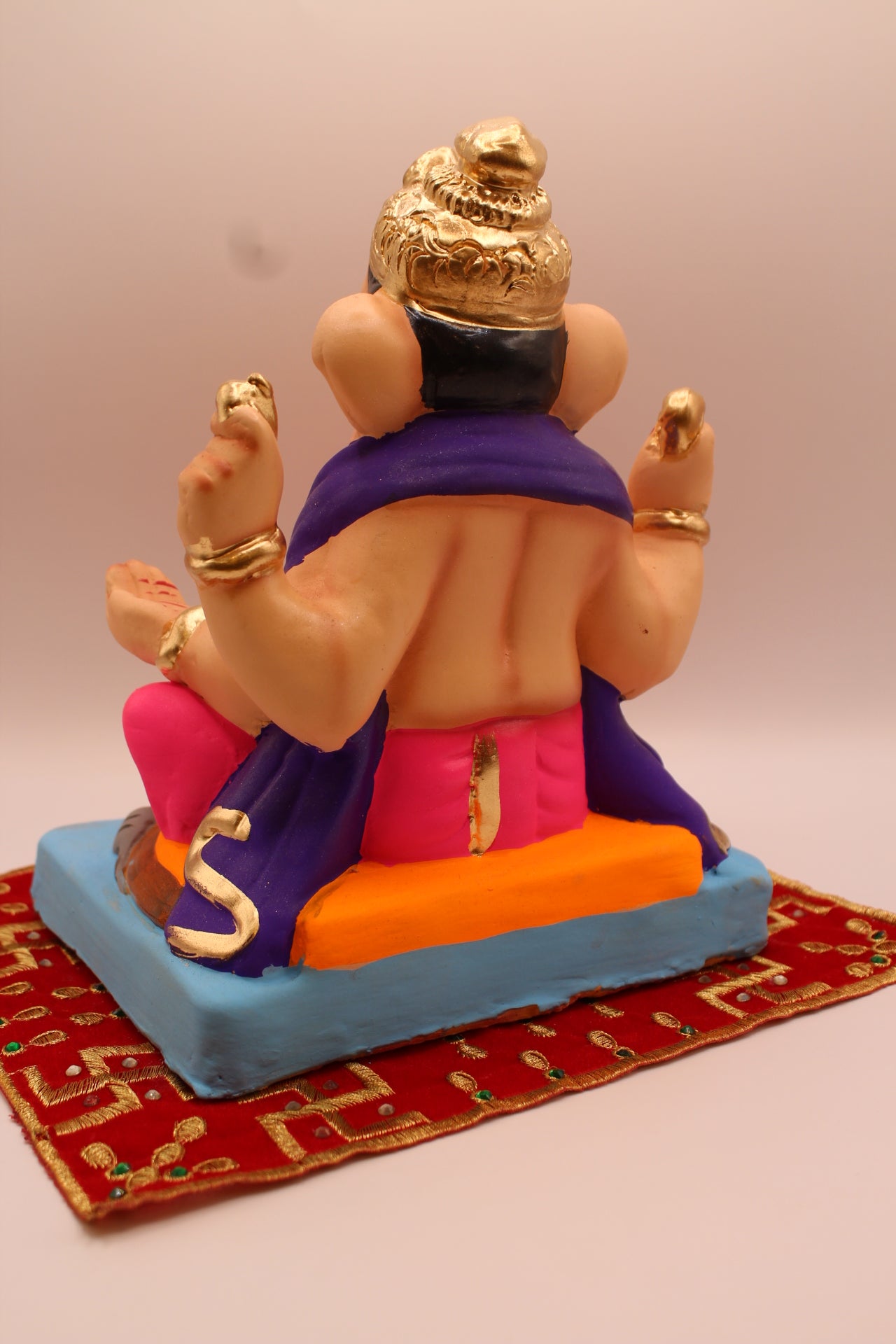 Eco-friendly 8 inch Ganesh Visarjan idol in purple shawl and rani pink dhoti – back view