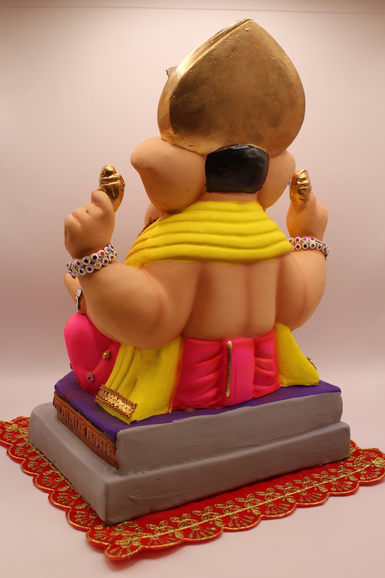 Back view – jewellery style idol with gold leaf mukut and yellow khes