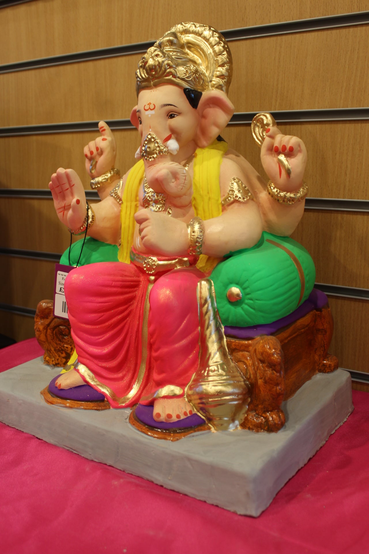 Angled view – yellow khes and rani pink dhoti on scroll-legged chowki
