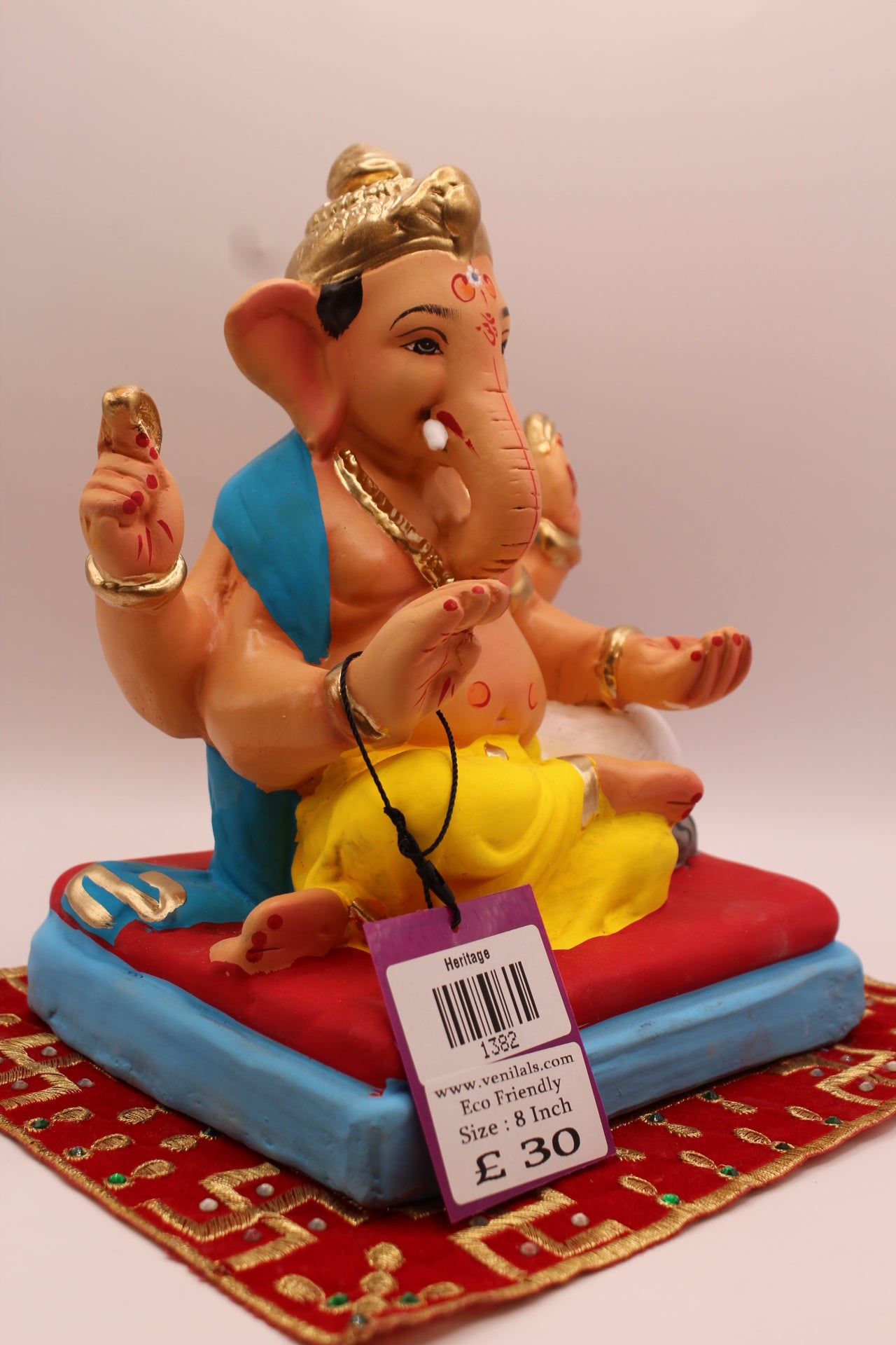Side view – teal khes and yellow dhoti on a red cushion