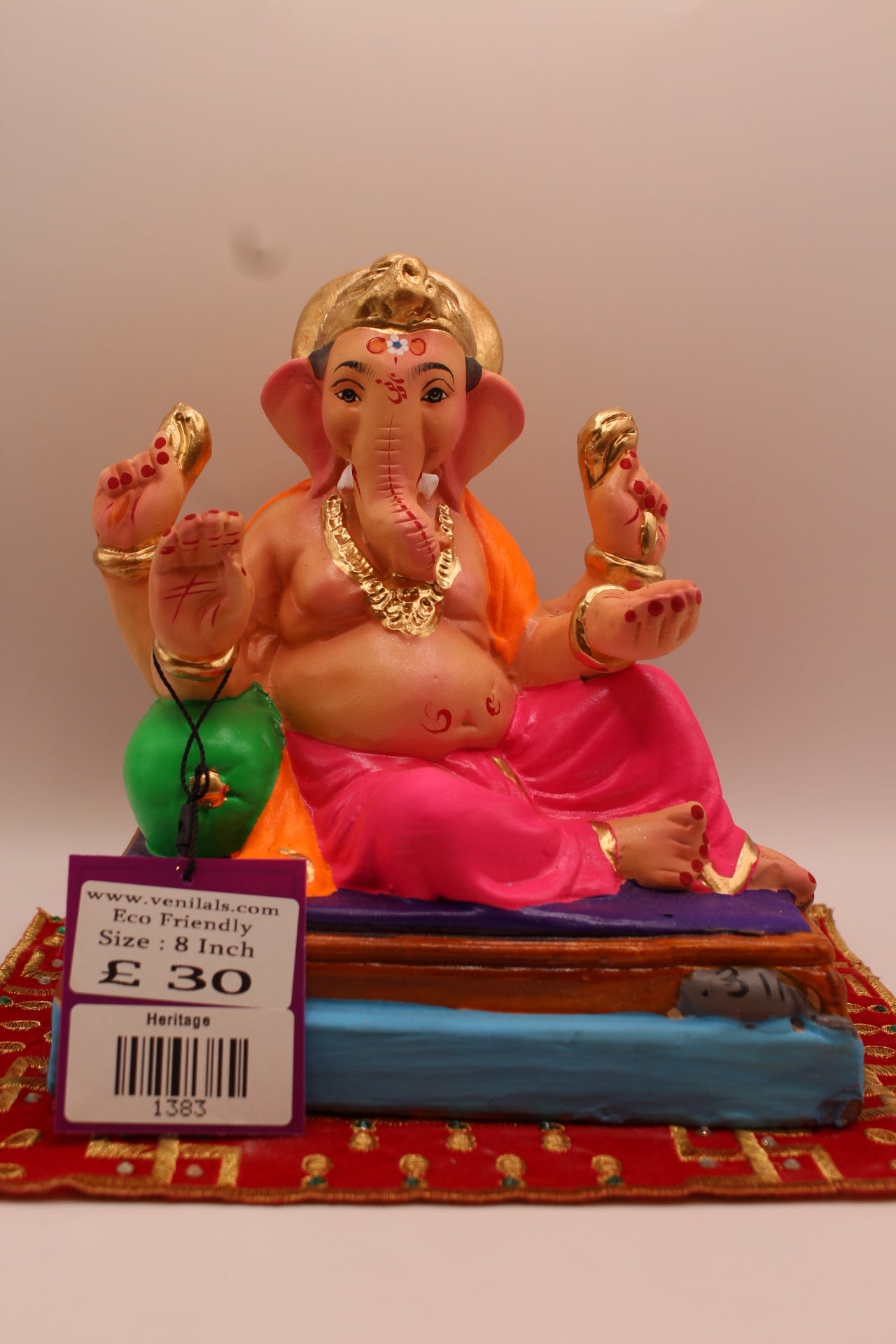 8 inch eco-friendly Ganesh idol – orange khes and pink dhoti reclining against a green cushion, front
