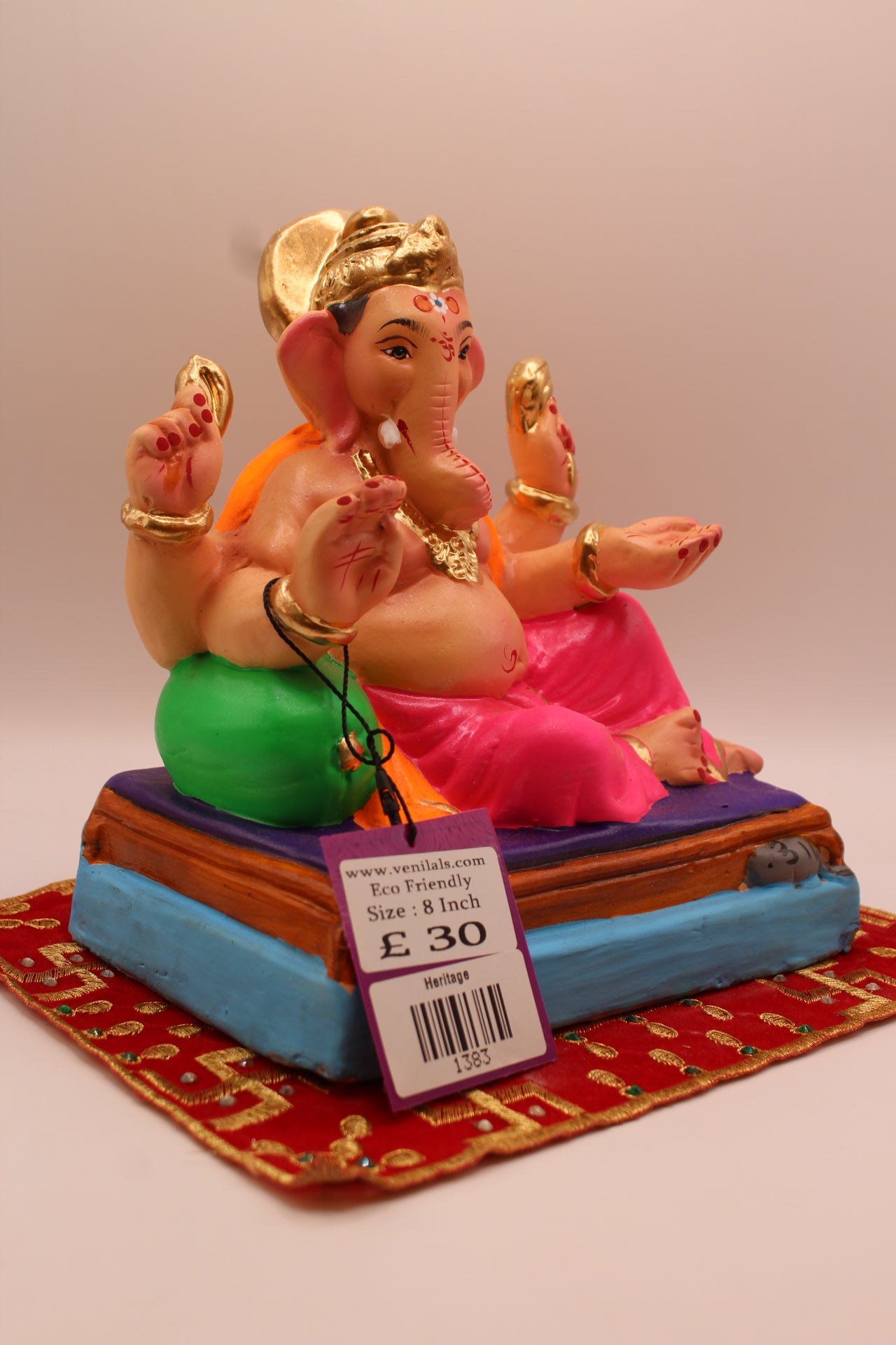 Side view – orange khes and pink dhoti reclining against a green cushion