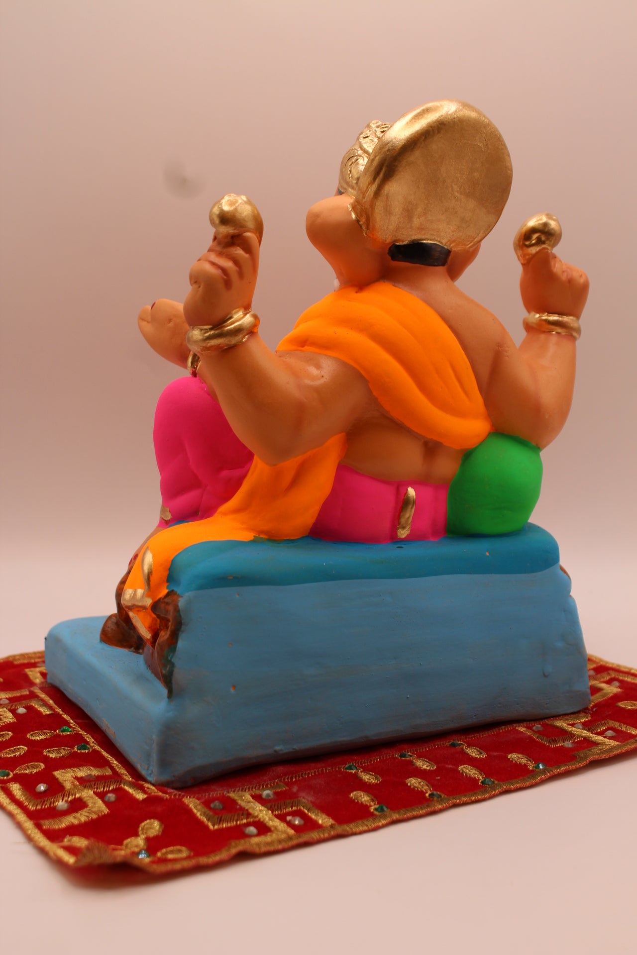 Back view – orange khes and pink dhoti with raised knee