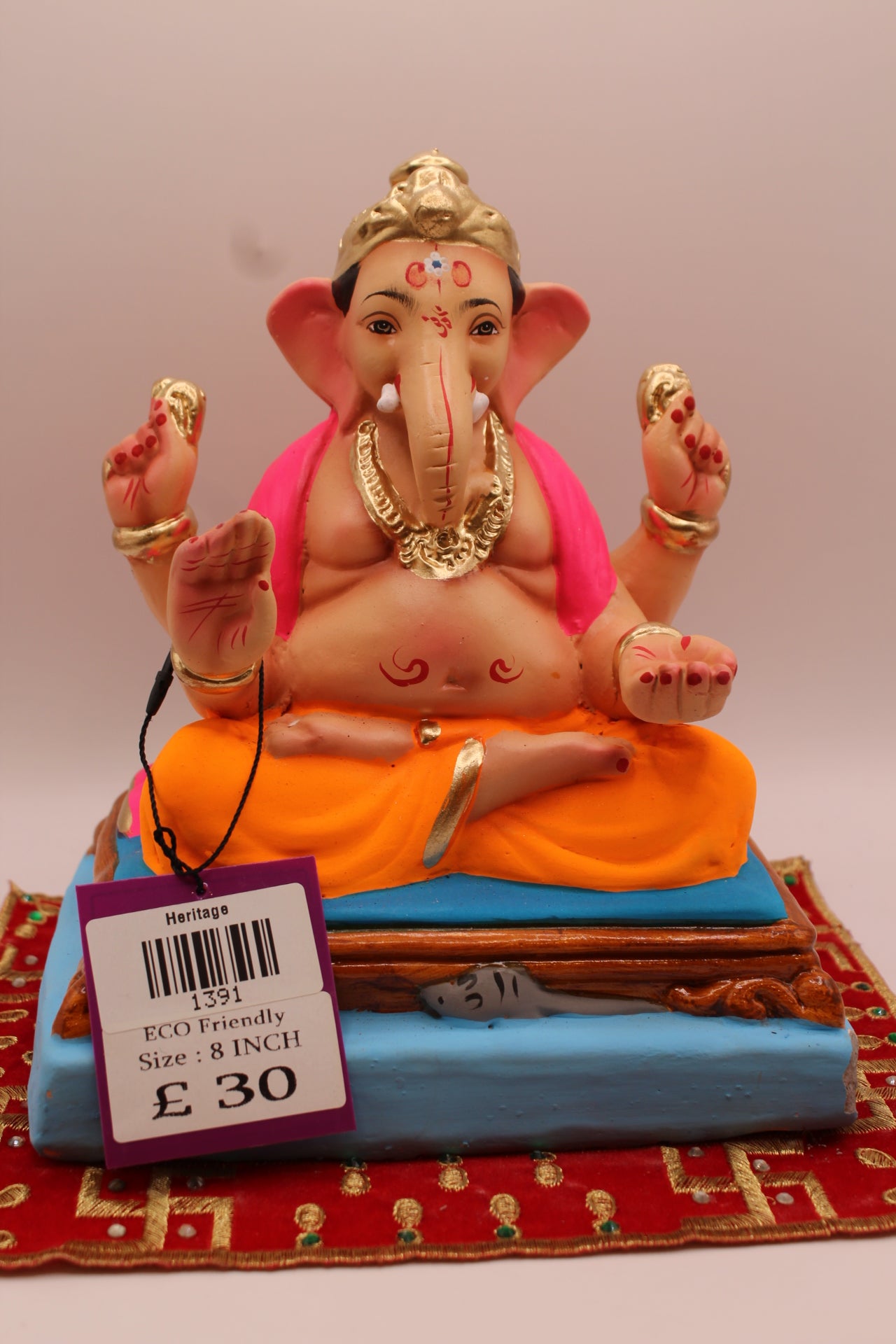 8 inch eco-friendly Ganesh idol – rani pink khes and orange dhoti on a purple mat, front