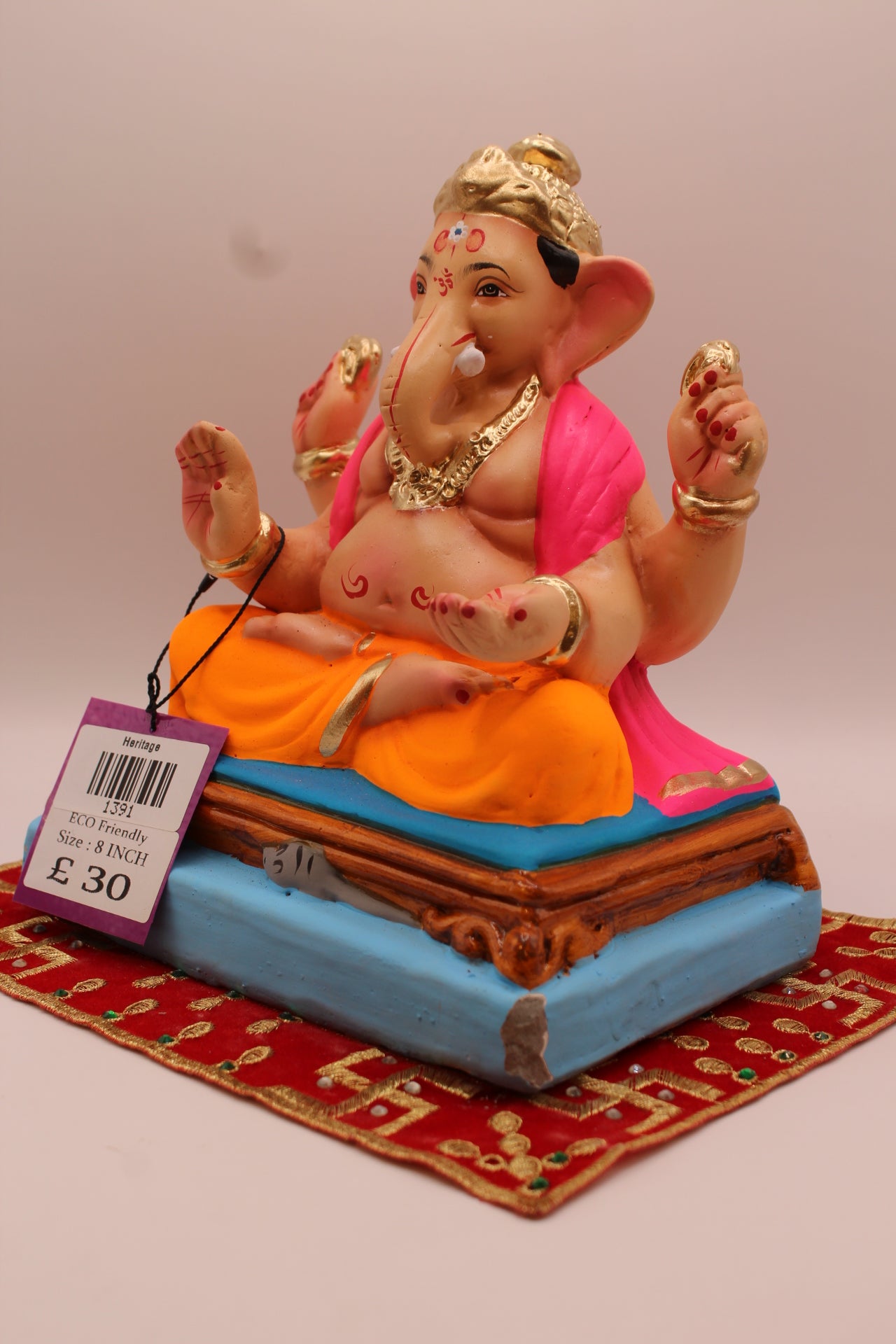 Angled view – rani pink khes and orange dhoti on a purple mat