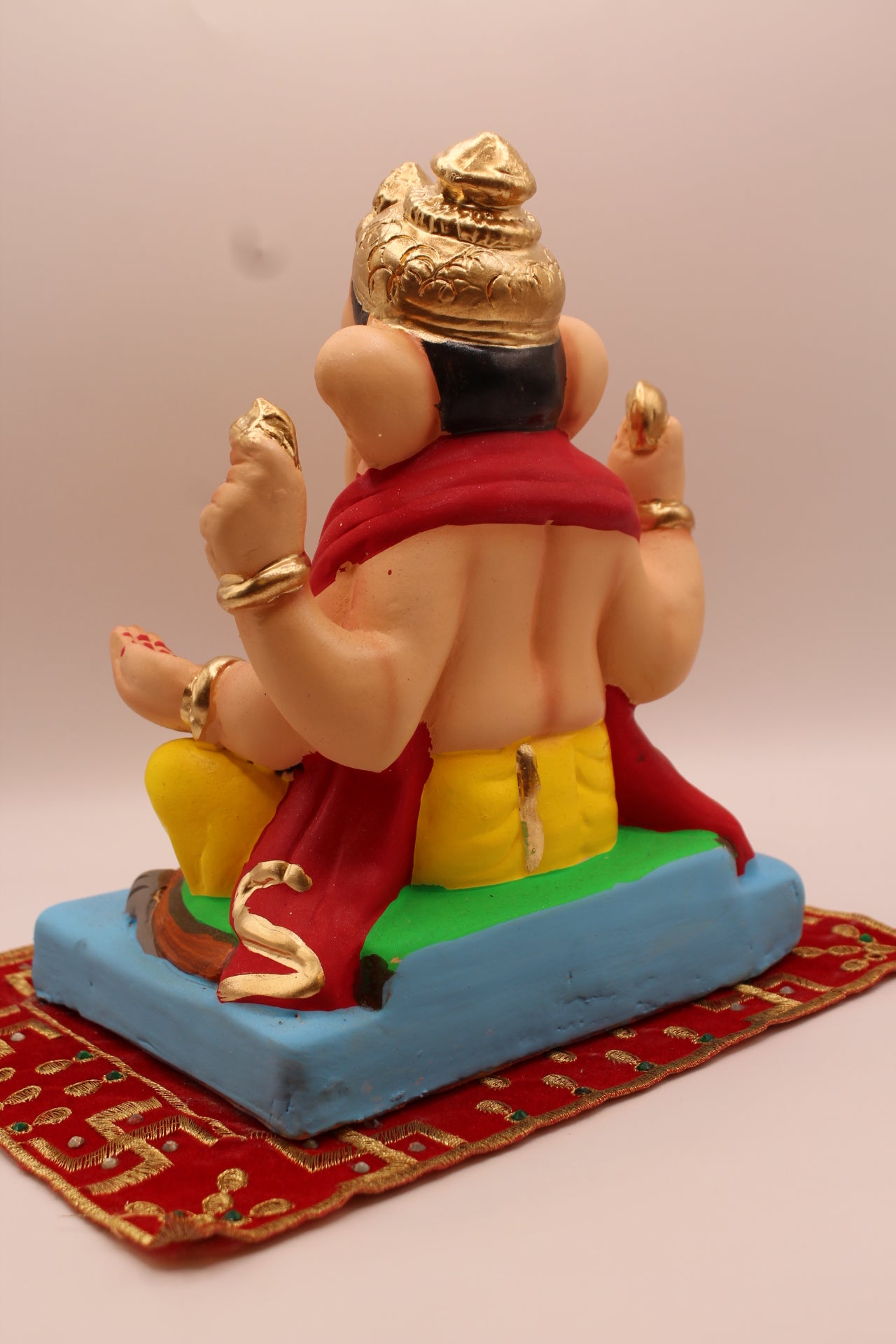Back view – red khes and yellow dhoti with fluted gold crown