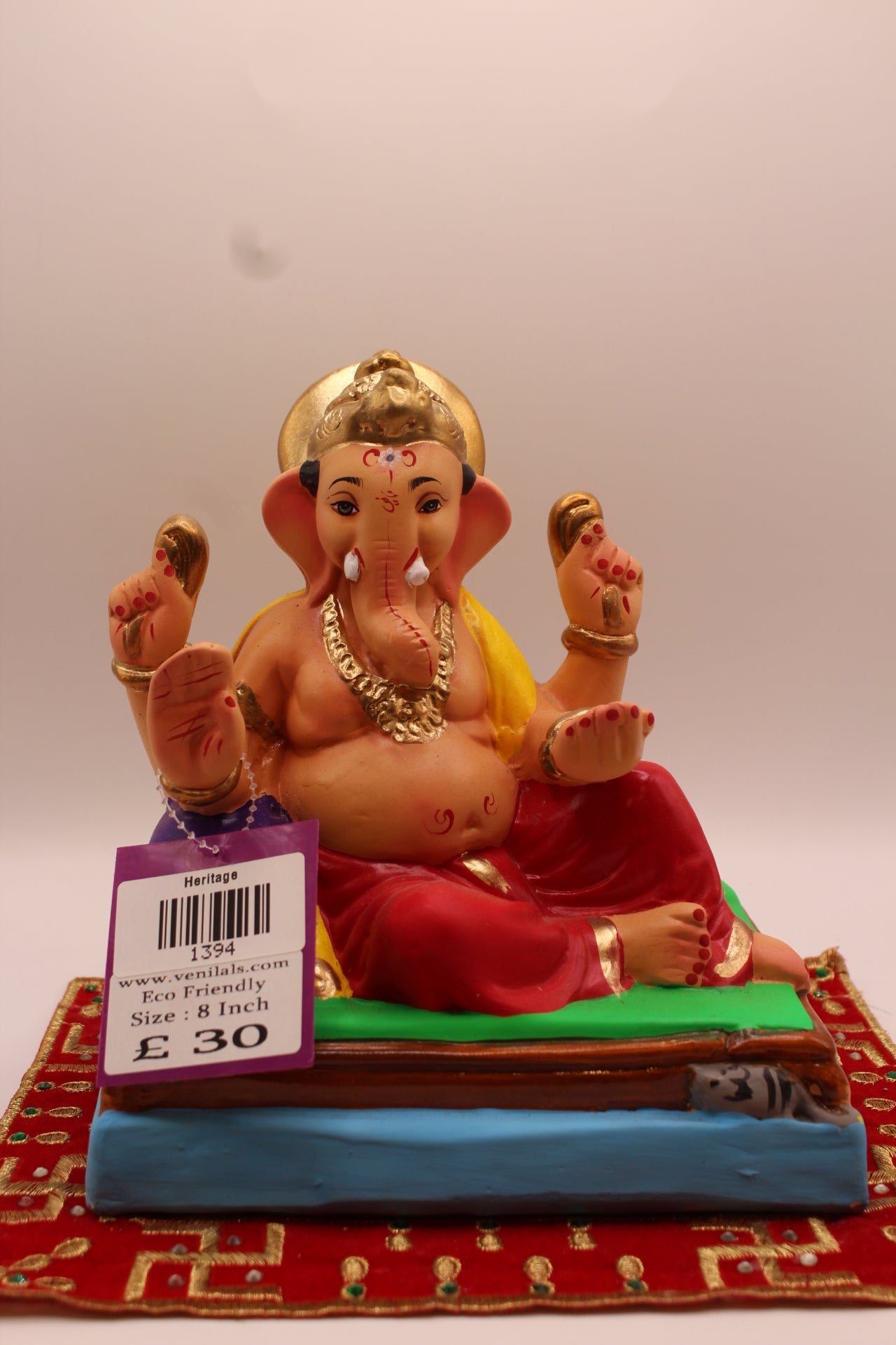 8 inch eco-friendly Ganesh idol – yellow khes and red dhoti reclining against a purple bolster, front