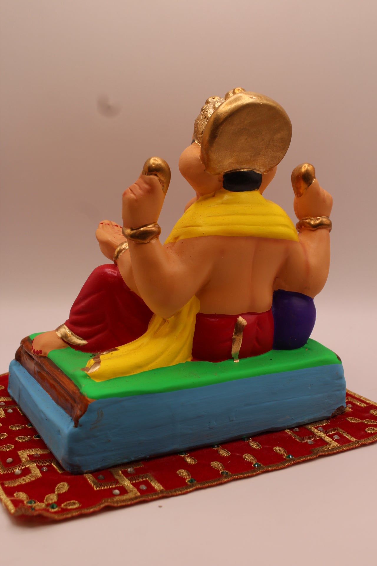 Back view – yellow khes and red dhoti reclining against a purple bolster