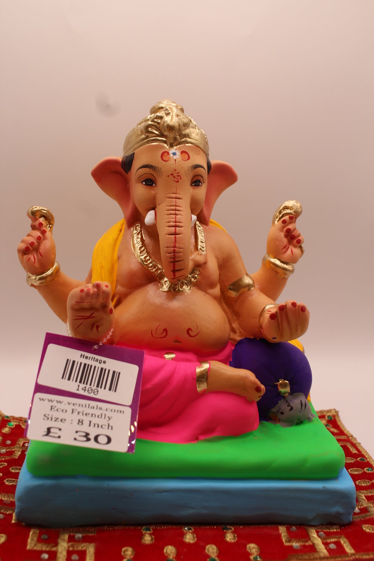 8 inch eco-friendly Ganesh idol – yellow khes and rani pink dhoti on a purple cushion, front