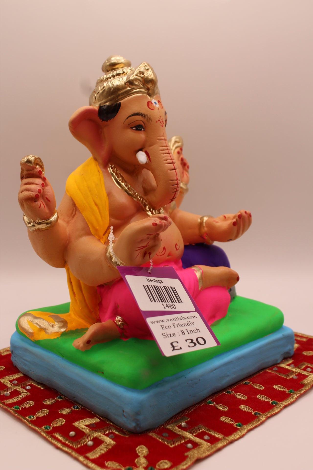 Side view – yellow khes and rani pink dhoti on a purple cushion