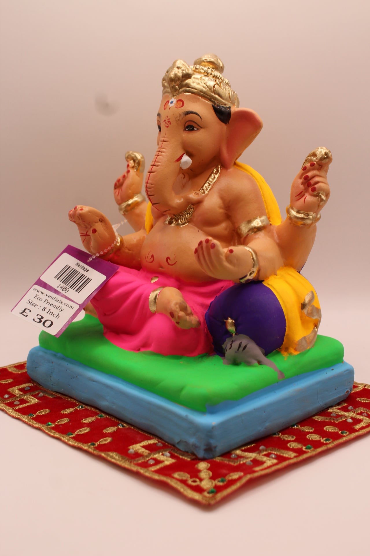 Angled view – yellow khes and rani pink dhoti on a purple cushion