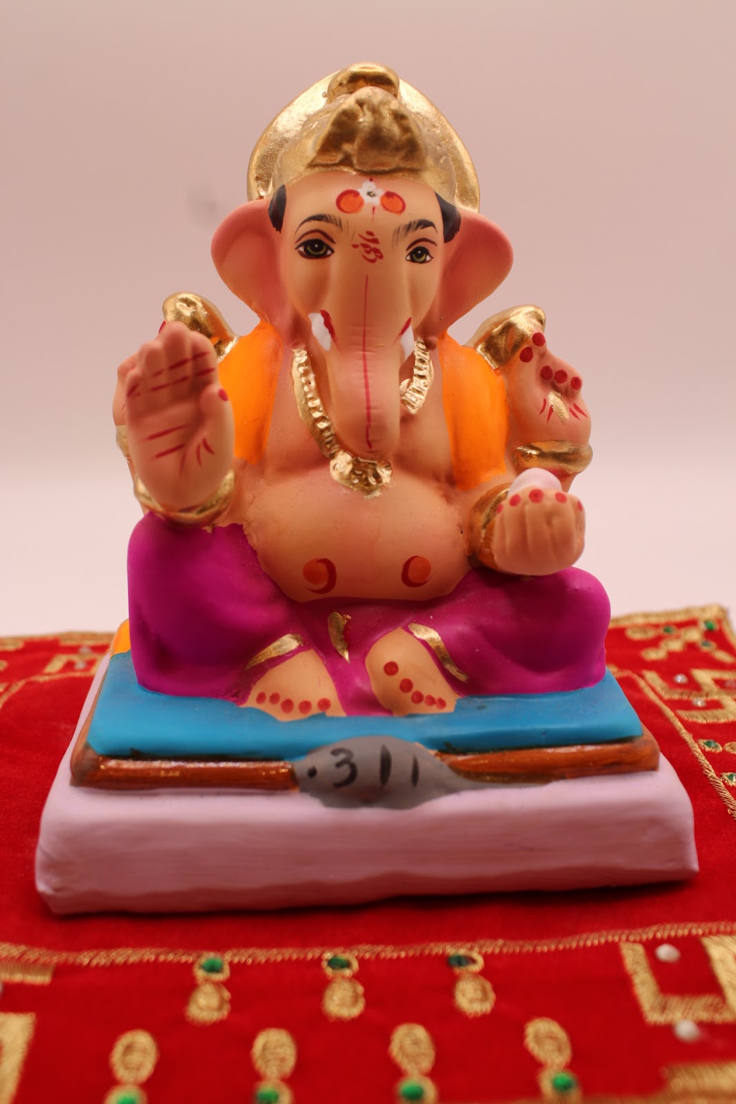 Eco-friendly 6 inch Ganesh idol with orange khes and magenta dhoti, front view