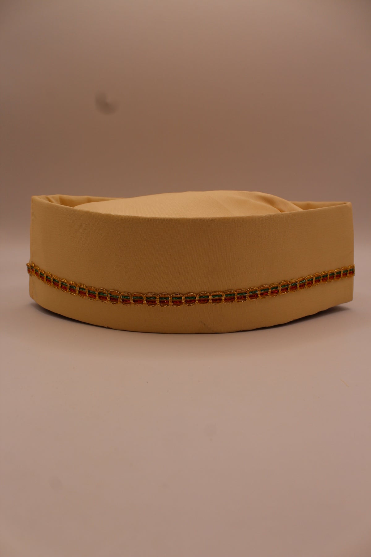 Cream Gandhi topi with gold braid trim, front view