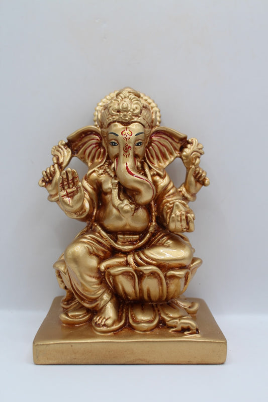 Gold resin Ganesh murti seated on a lotus, front view