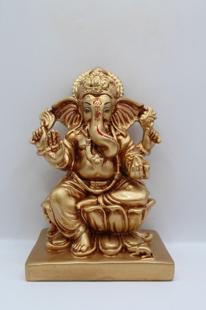 Gold resin Ganesh murti seated on a lotus, front view