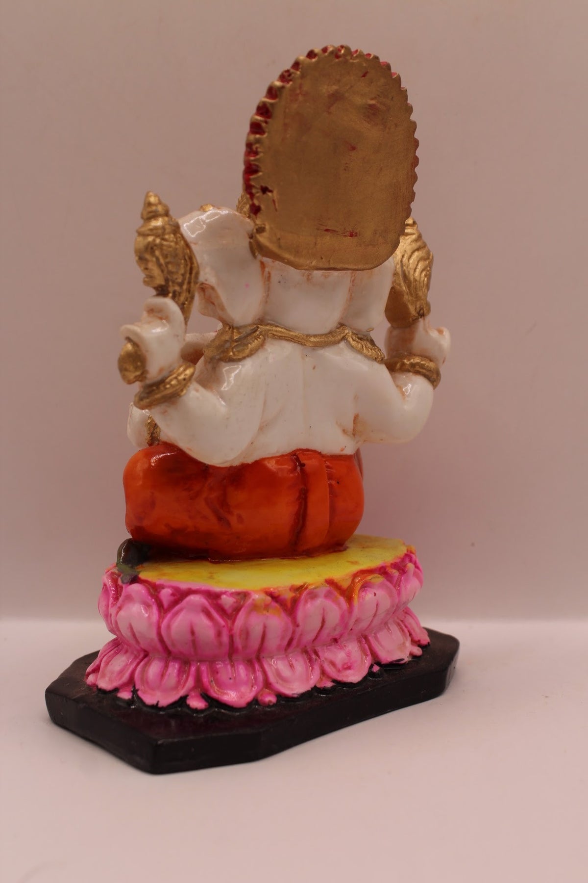 Resin Ganesh murti on pink lotus with orange dhoti, back view