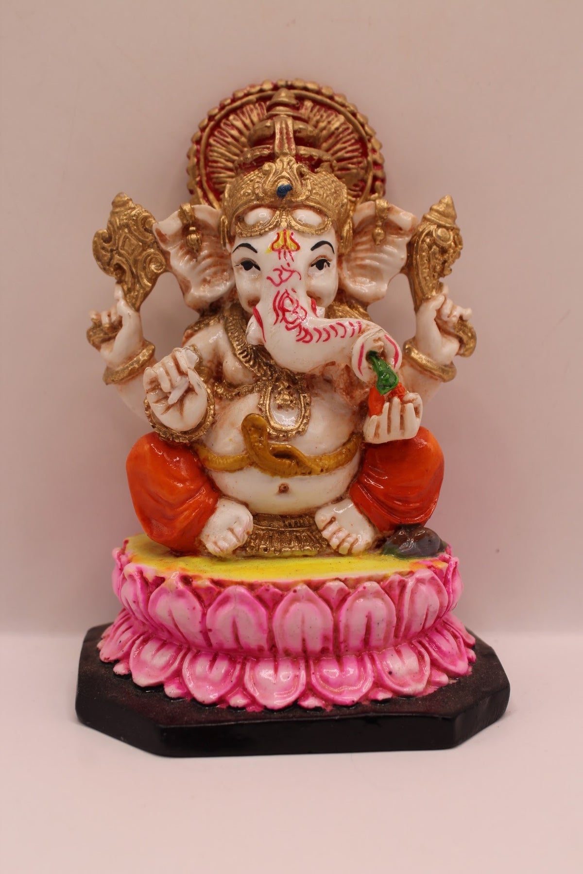 Resin Ganesh murti on pink lotus with orange dhoti, front view