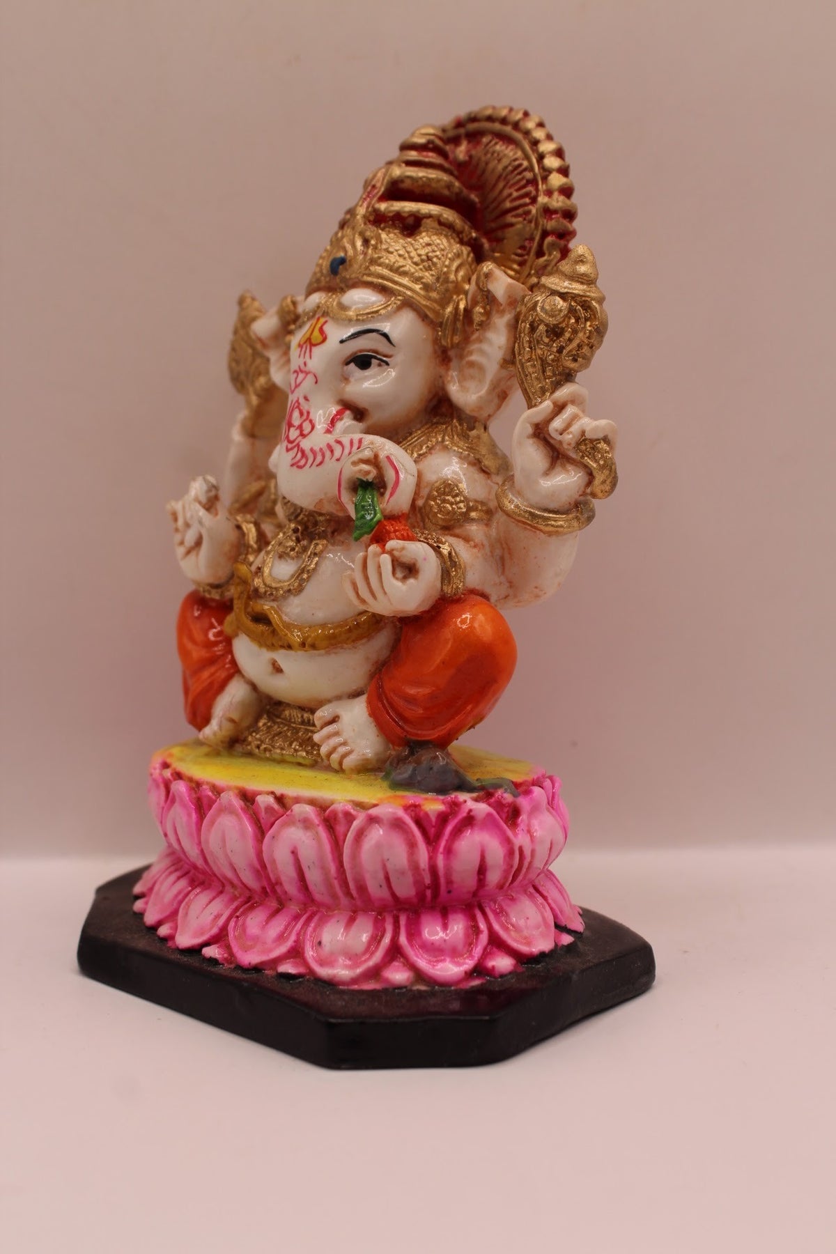 Resin Ganesh murti on pink lotus with orange dhoti, right side view