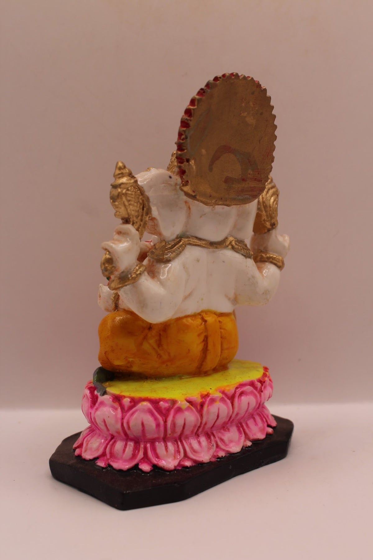 Resin Ganesh murti on pink lotus with yellow dhoti, back view