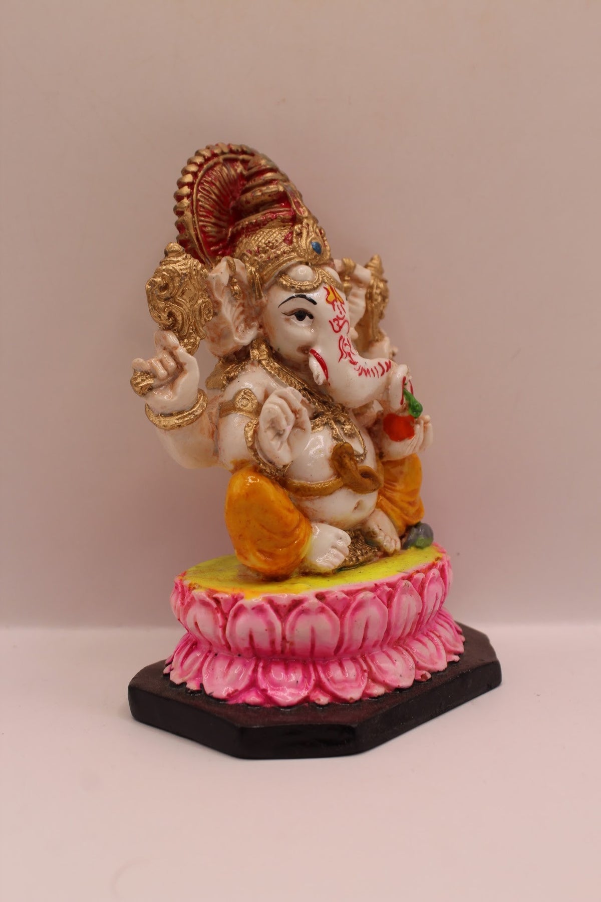 Resin Ganesh murti on pink lotus with yellow dhoti, left side view