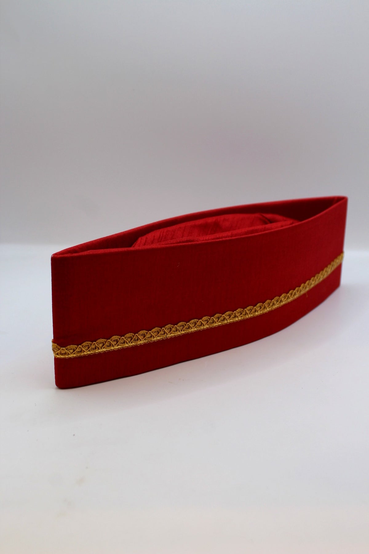 Red Gandhi topi with golden border, side view