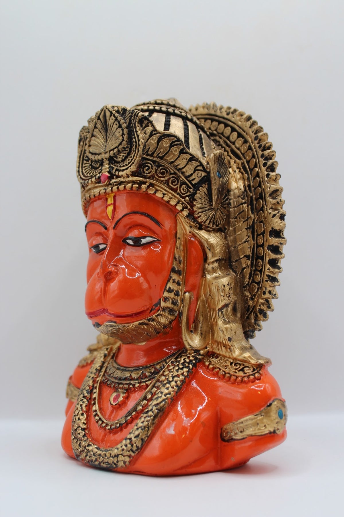 Orange resin Hanuman bust with gold crown, right side view