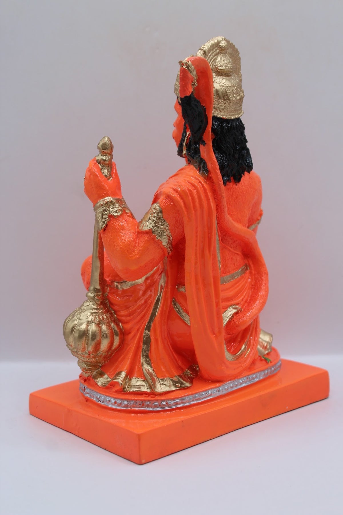Orange resin Hanuman murti kneeling with gada, back view