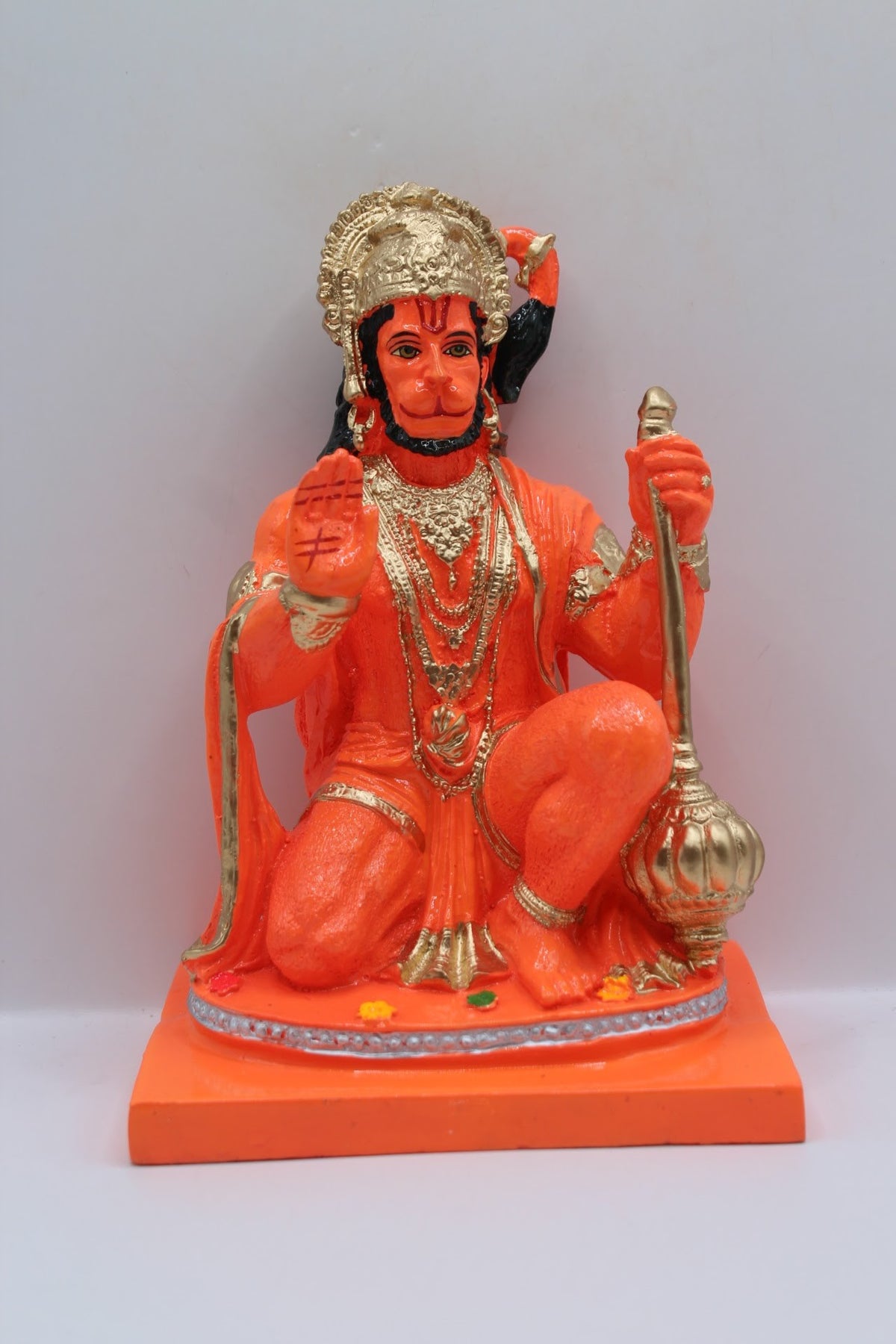 Orange resin Hanuman murti kneeling with gada, front view