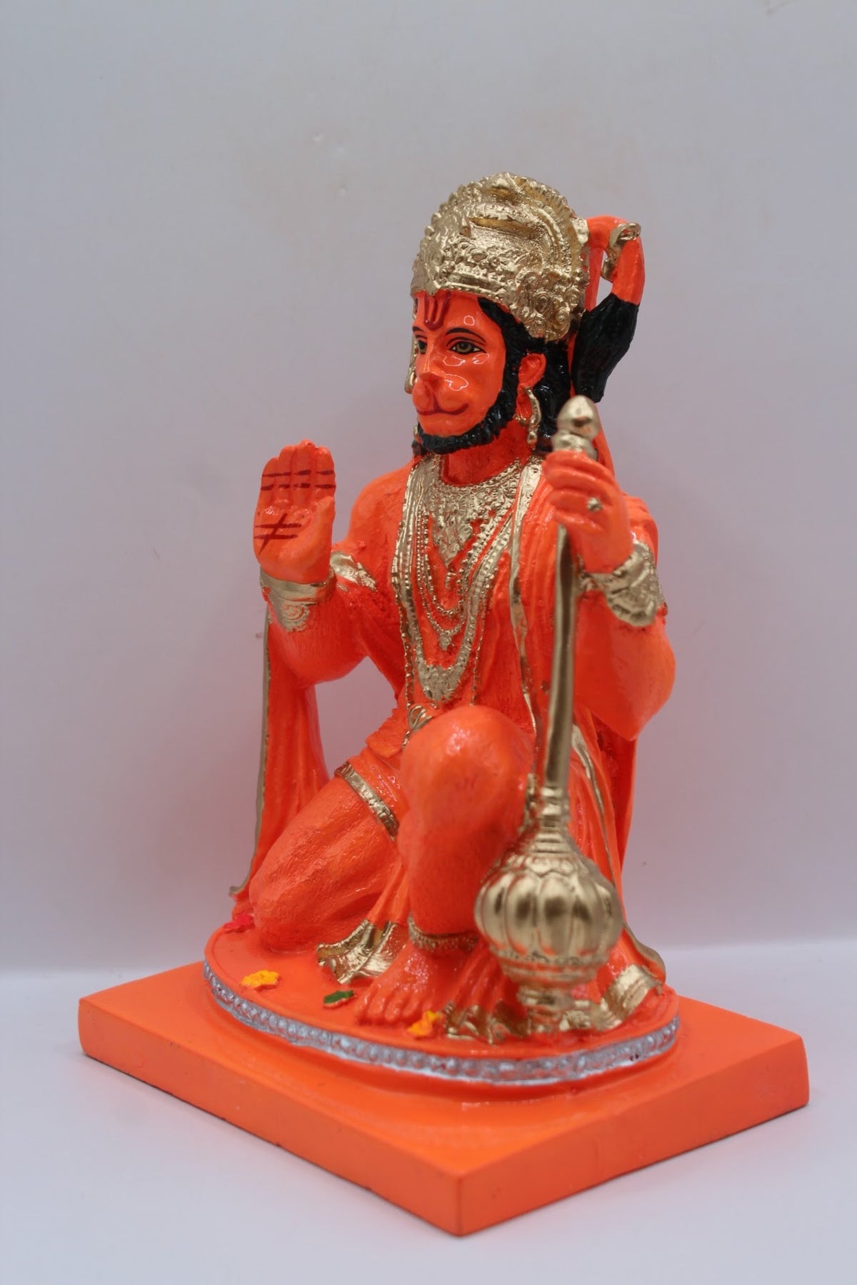 Orange resin Hanuman murti kneeling with gada, right side view
