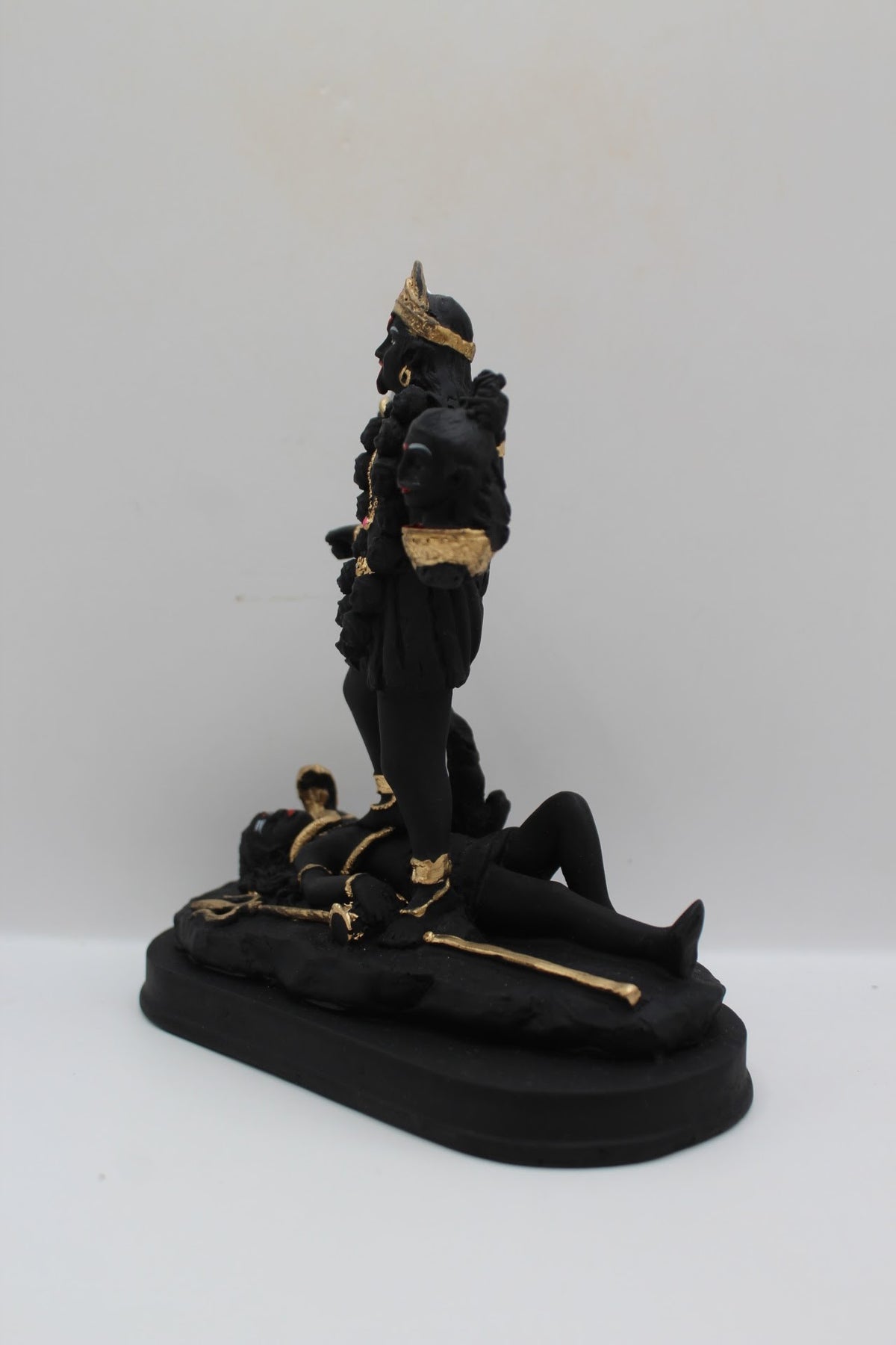 Black and gold resin Kali Mata murti standing on Shiva, right side view