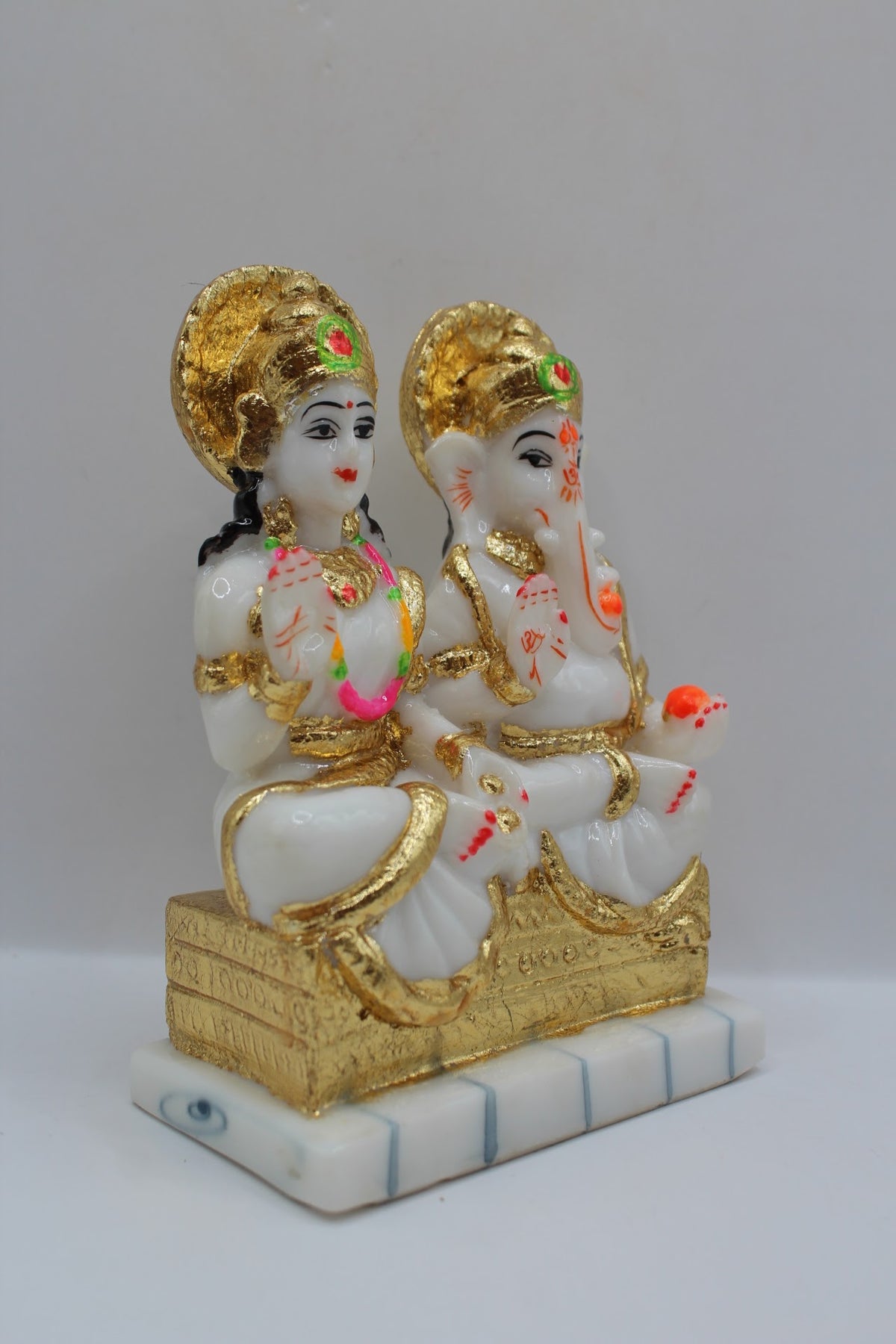 White and gold resin Laxmi Ganesh murti pair, left side view