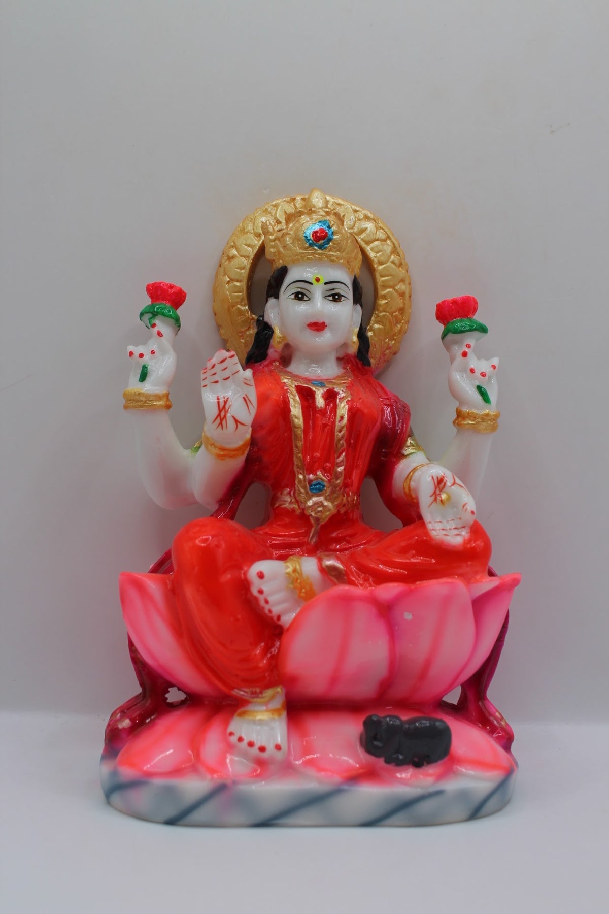 Red resin Laxmi murti on a pink lotus, front view