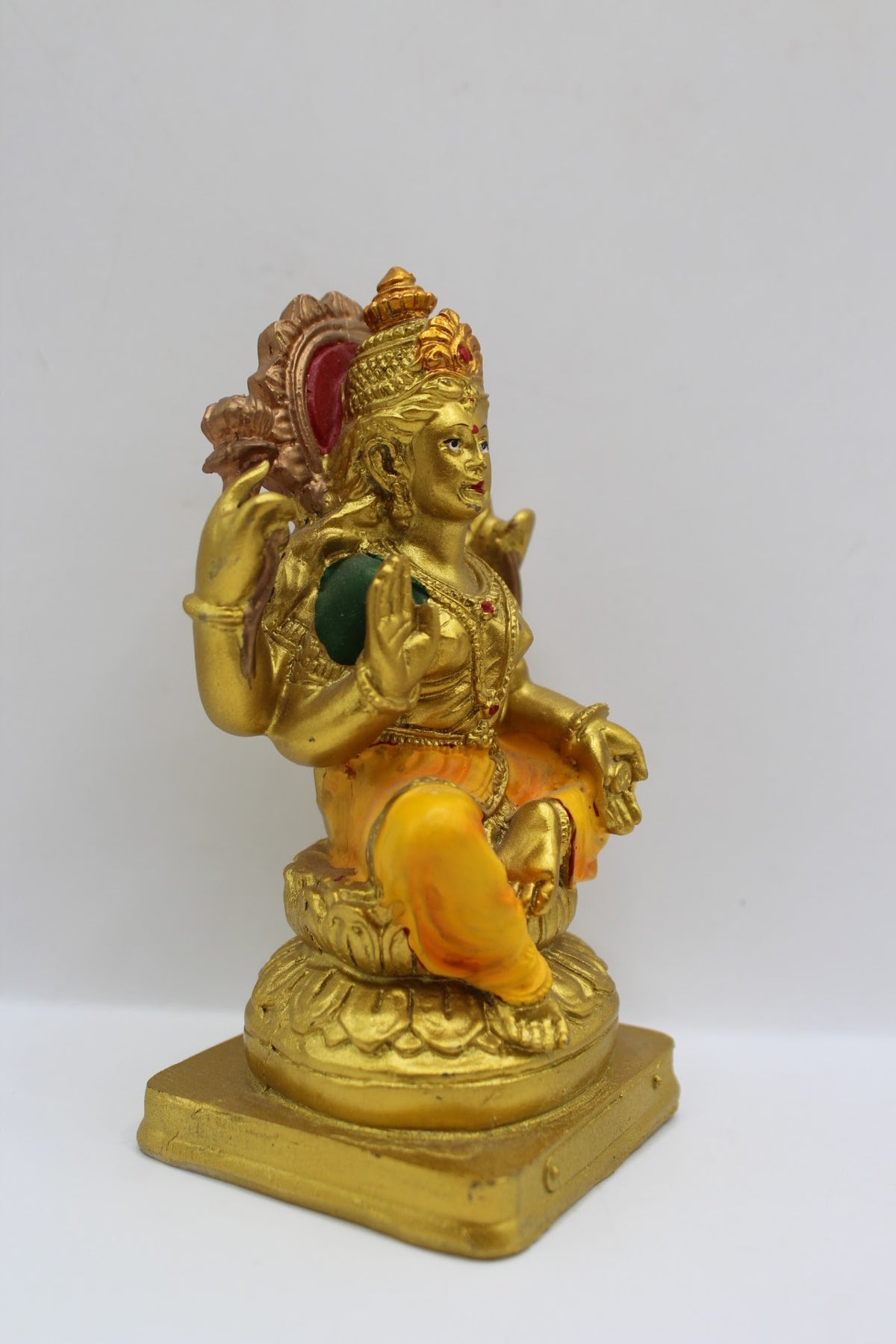 Small gold resin Laxmi murti with yellow clothes, left side view