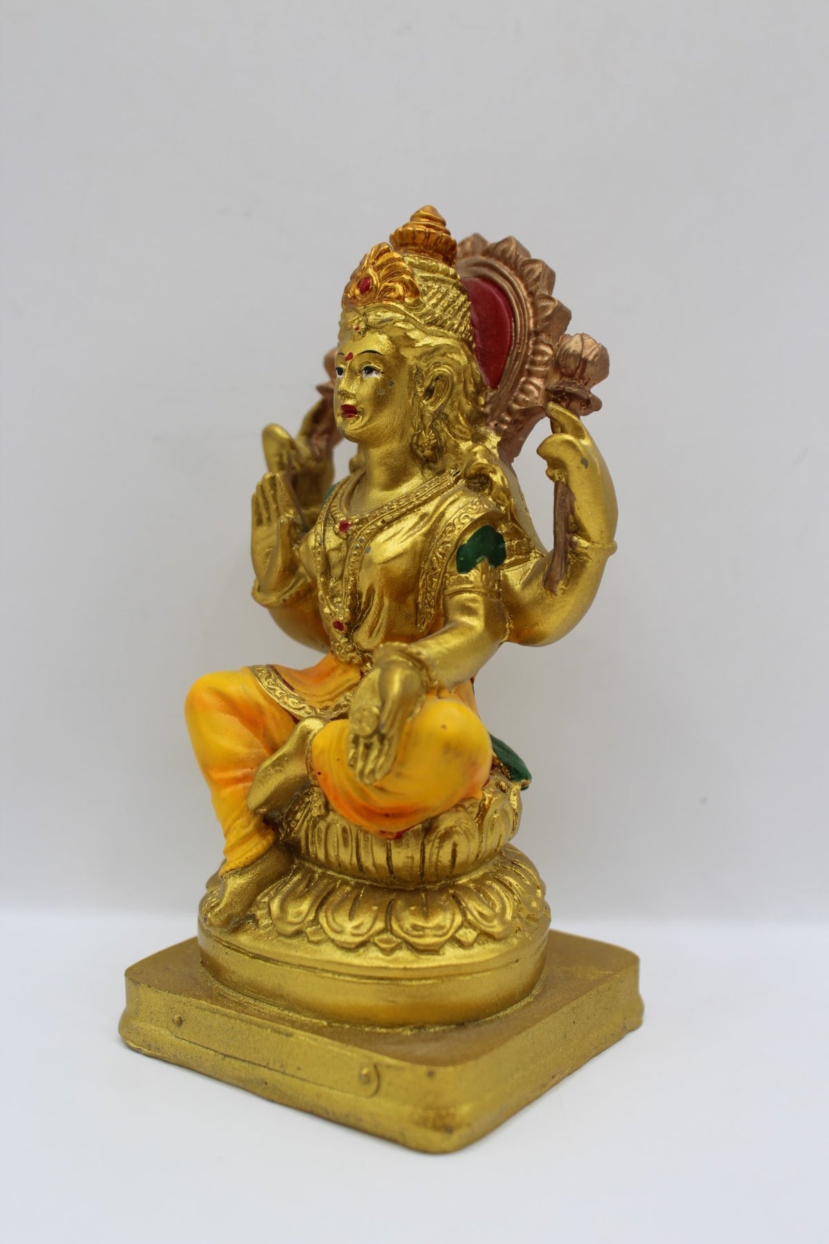 Small gold resin Laxmi murti with yellow clothes, right side view