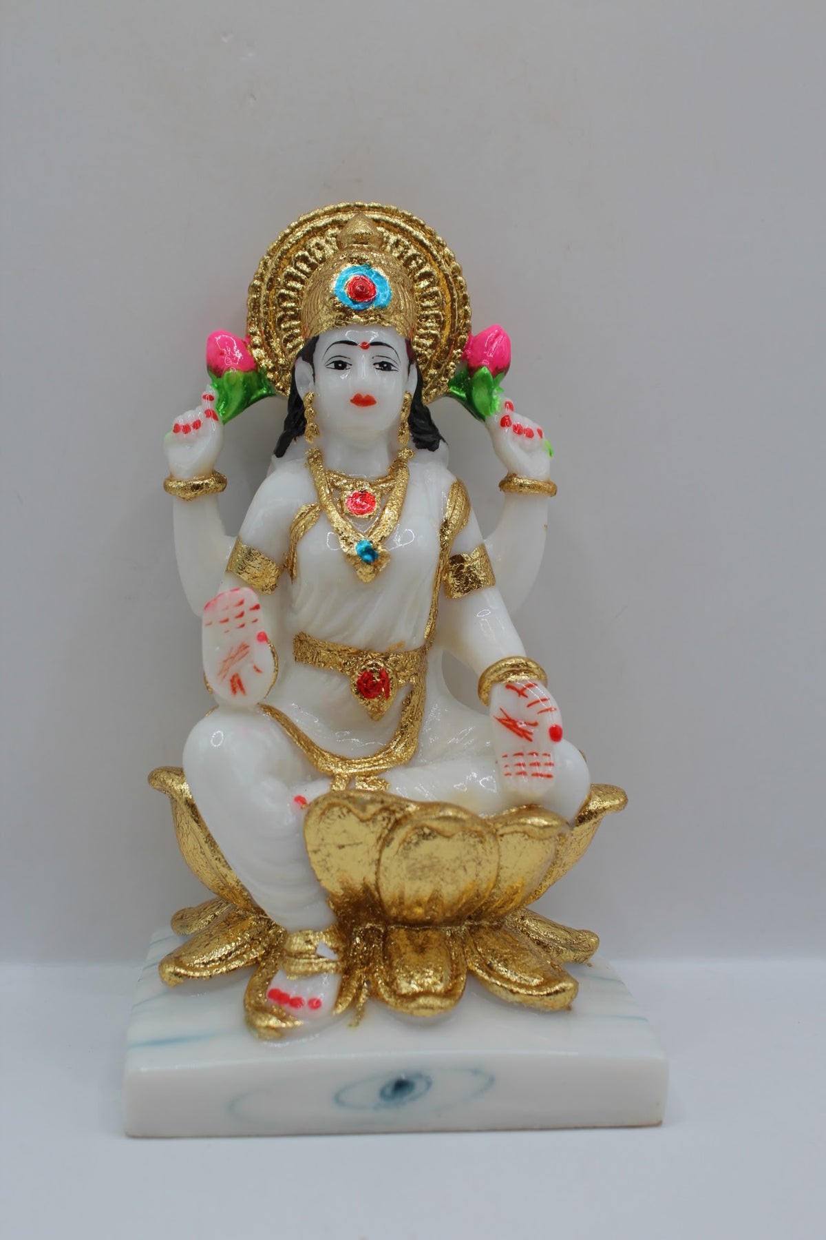 White and gold resin Laxmi murti on a gold lotus, front view