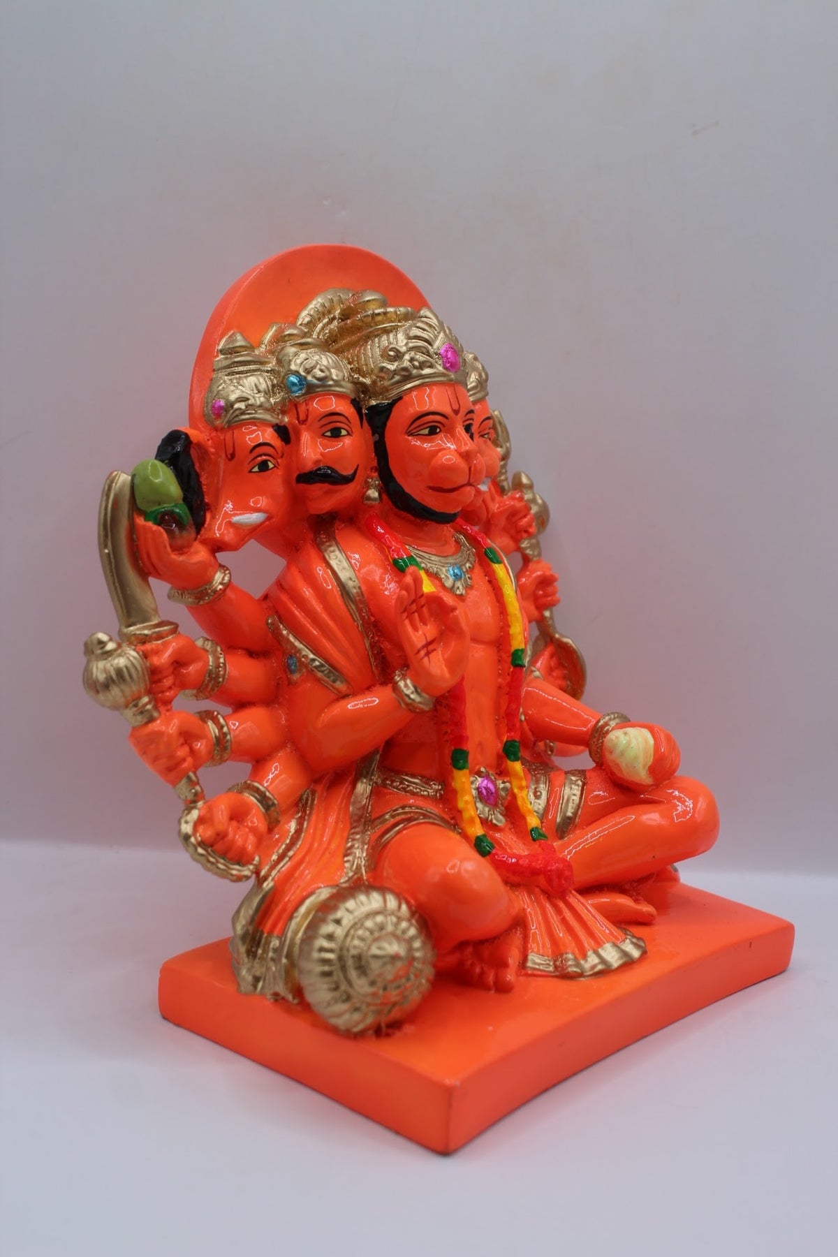 Orange resin Panchmukhi Hanuman murti, seated, left side view