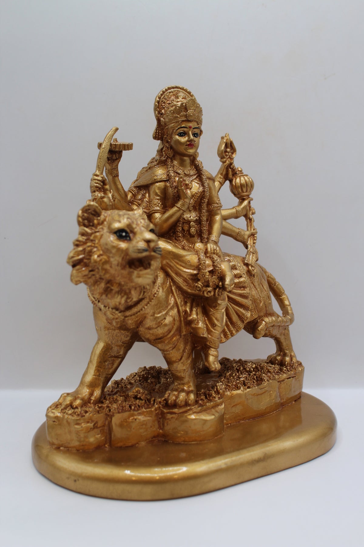 Resin Ambe Maa statue, golden finish, seated on lion, left side view
