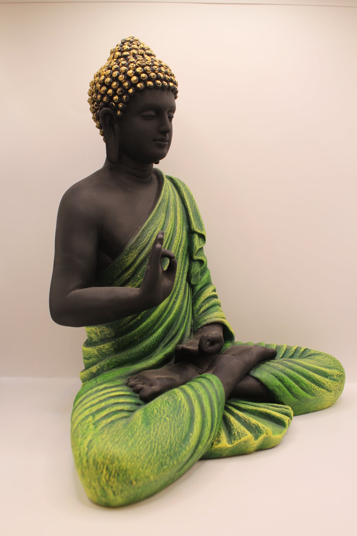 Forest green Buddha statue, left side