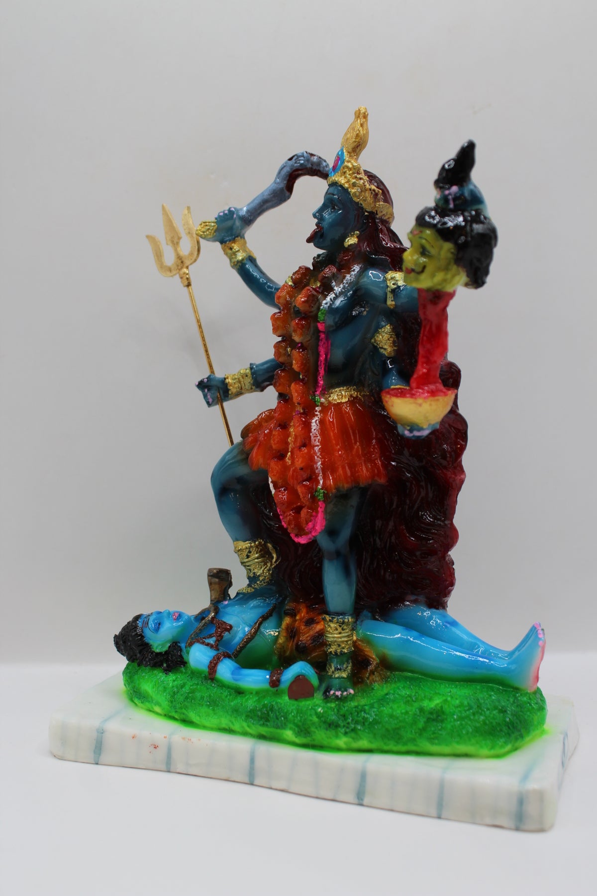 Resin Kali Mata statue, blue kali on green base, right side view