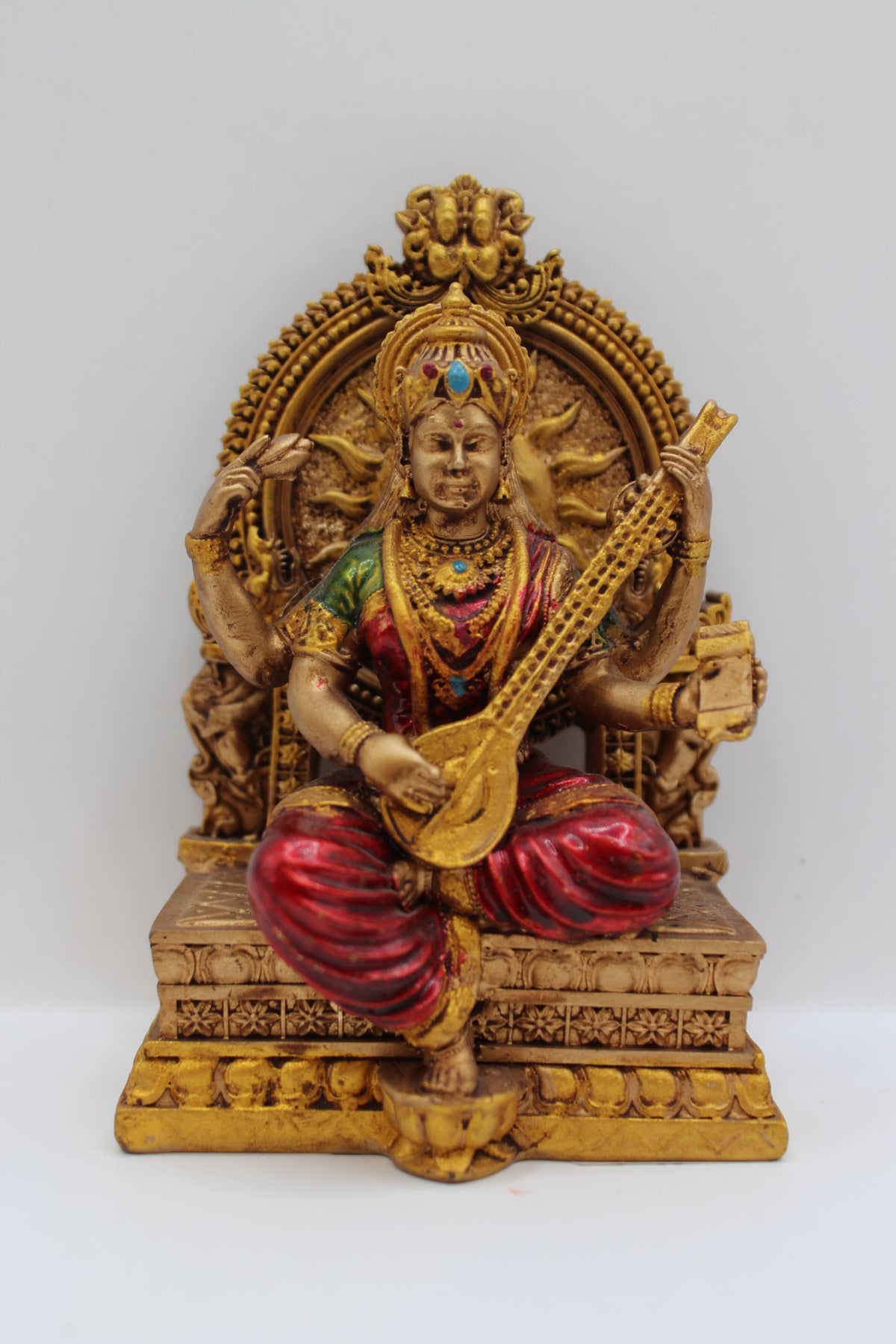 Resin Saraswati statue, seated on throne, antique bronze, front view