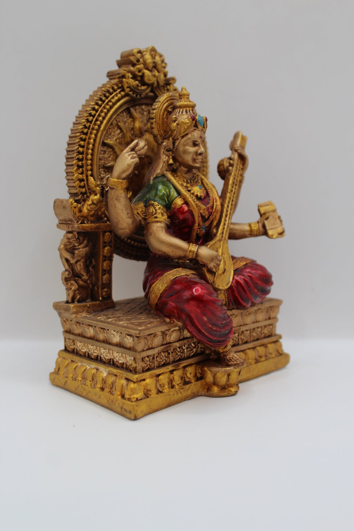 Resin Saraswati statue, seated on throne, antique bronze, left side view