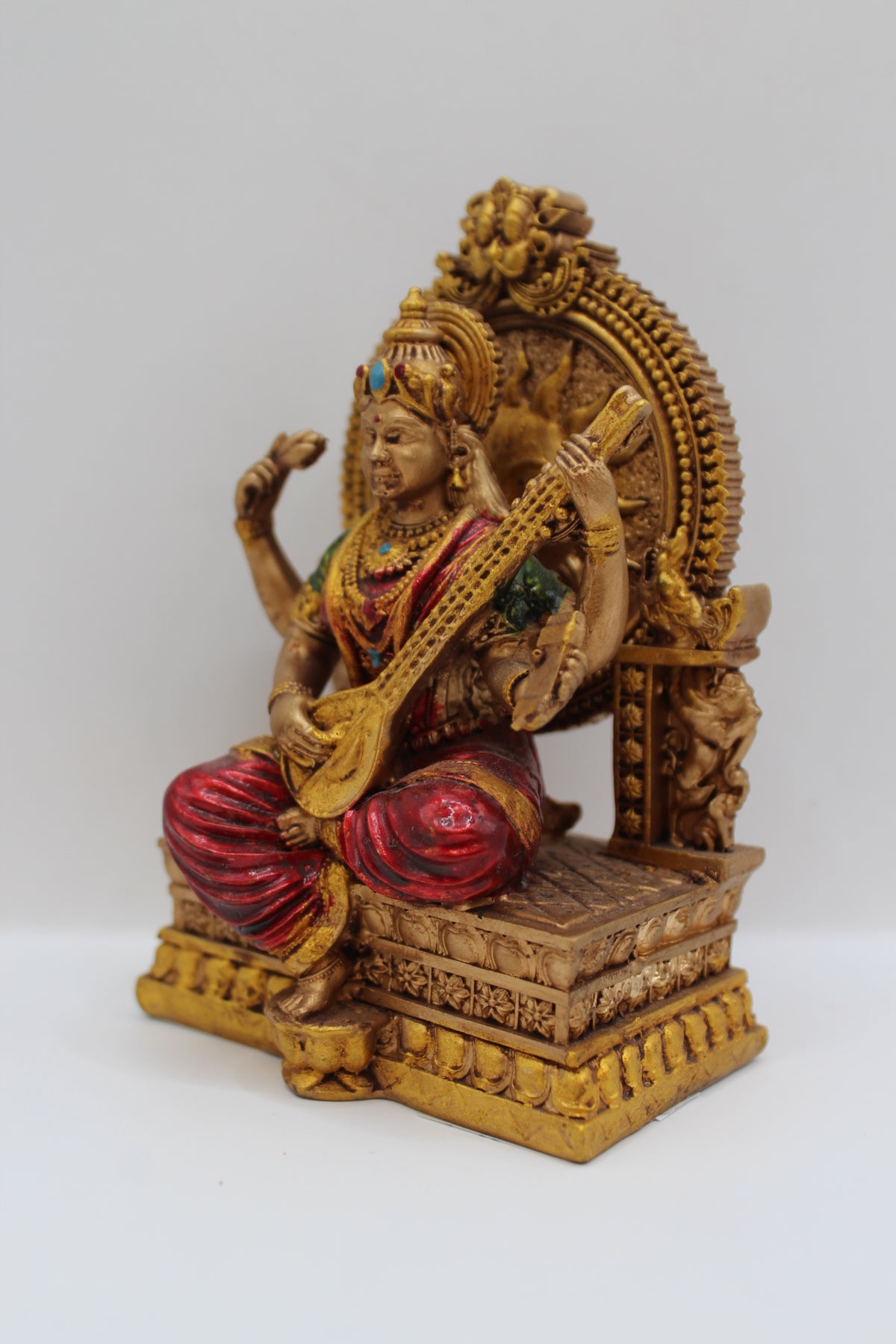 Resin Saraswati statue, seated on throne, antique bronze, right side view