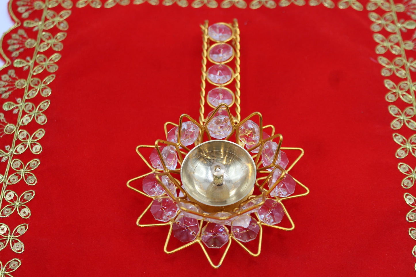 Gold-tone lotus aarti diya set with faceted pink stones and a jewelled handle