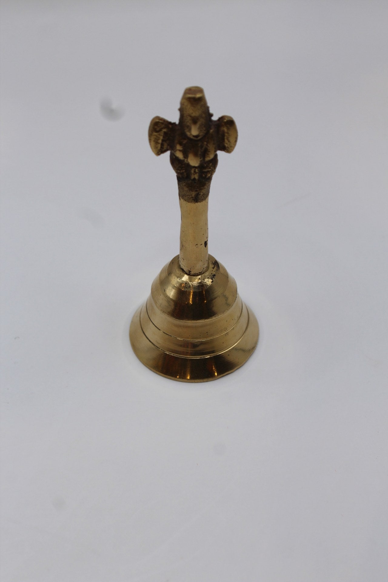 Solid brass pooja bell with a stepped skirt and cast handle