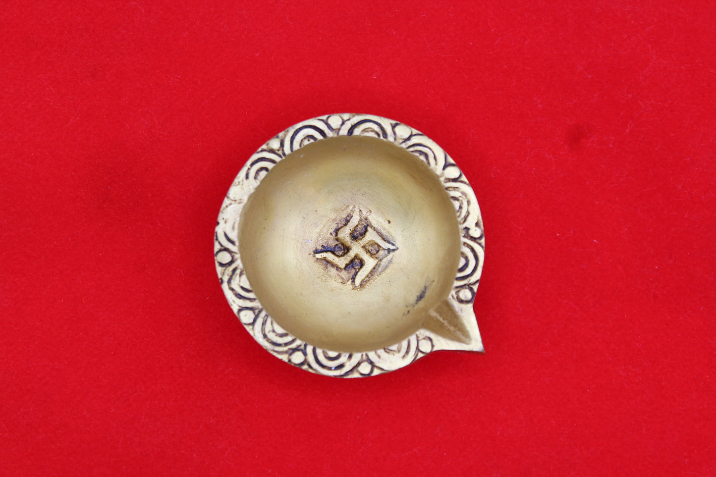 Brass diya, scrollwork band round the rim