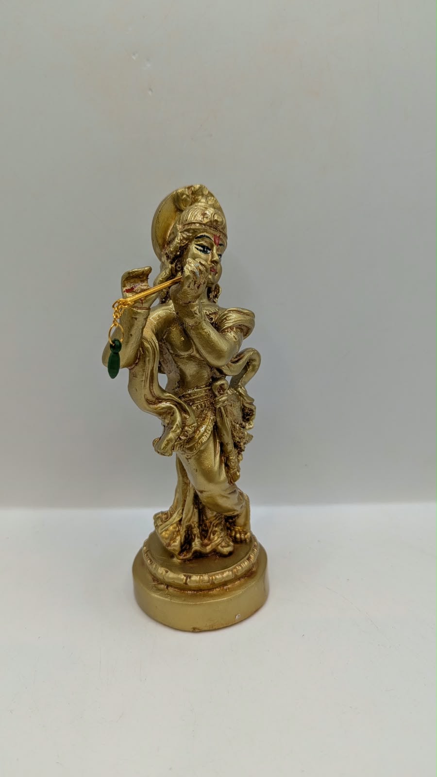 Gold Lord Krishna statue with flute, side view